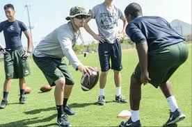 Football coach running player through drills