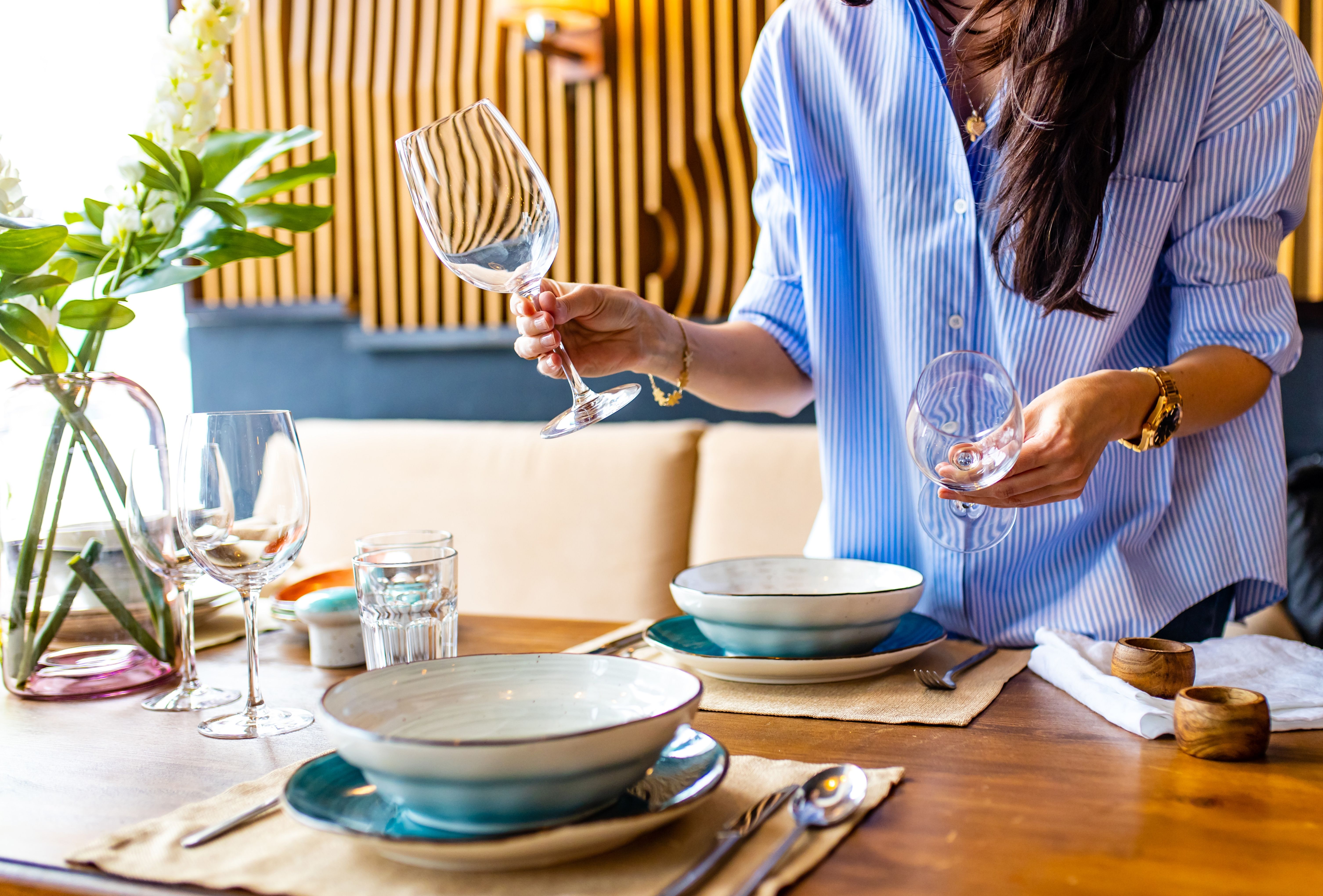A host arranging final details in a home freshened by a pre-event cleaning service. A host arranging final details in a home freshened by a pre-event cleaning service.