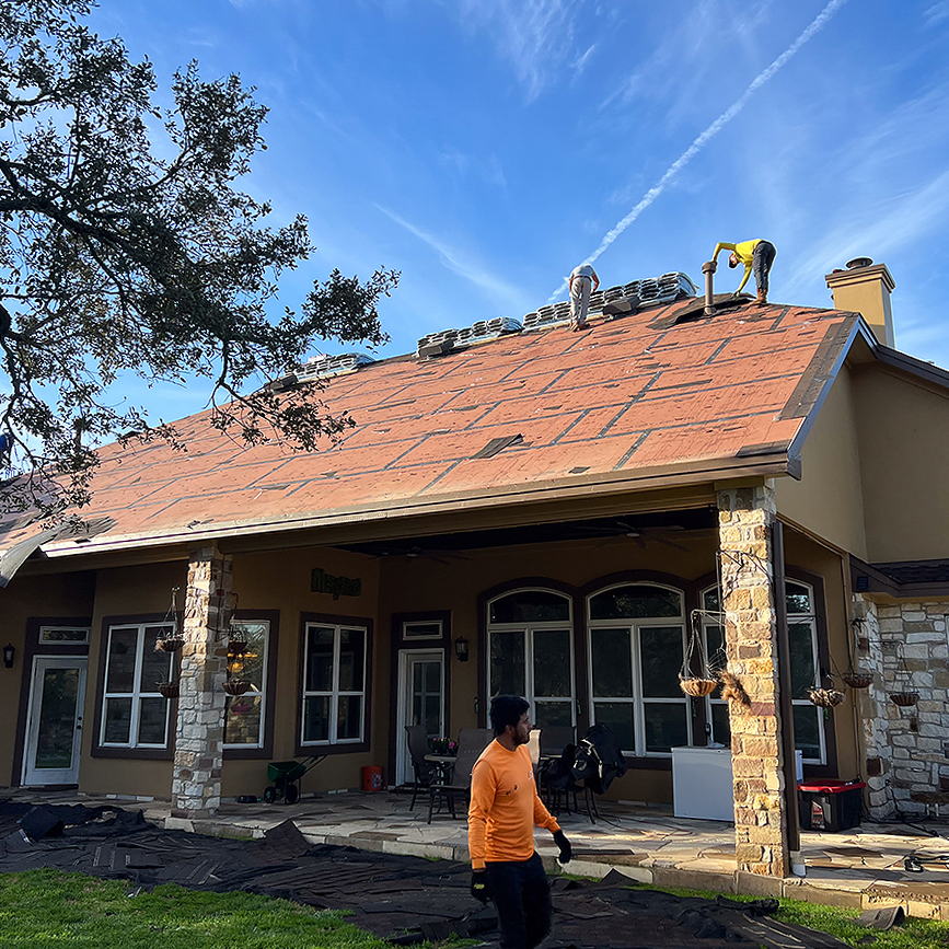 Round Rock Roofing crew tearing off an old roof down to the decking