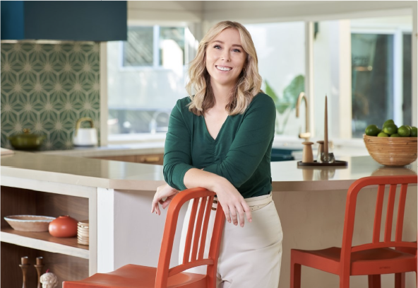 Andrea of Jeffery Design Studio standing in a colorful kitchen interior.