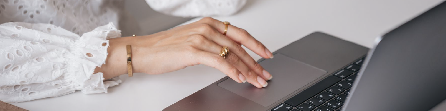 Designer using a laptop at a workspace.