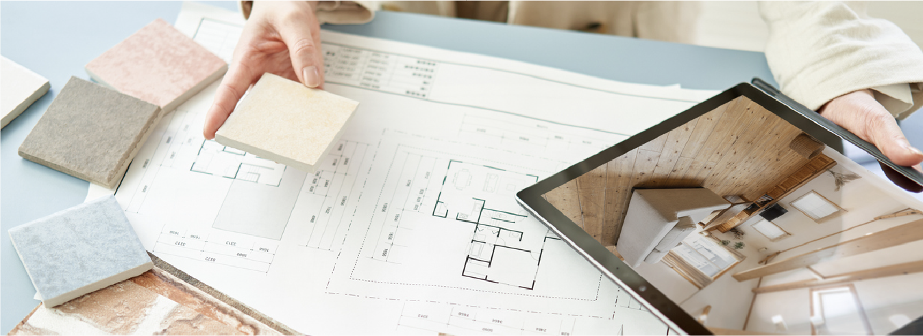 Interior designer reviewing floor plans, material samples, and a tablet.