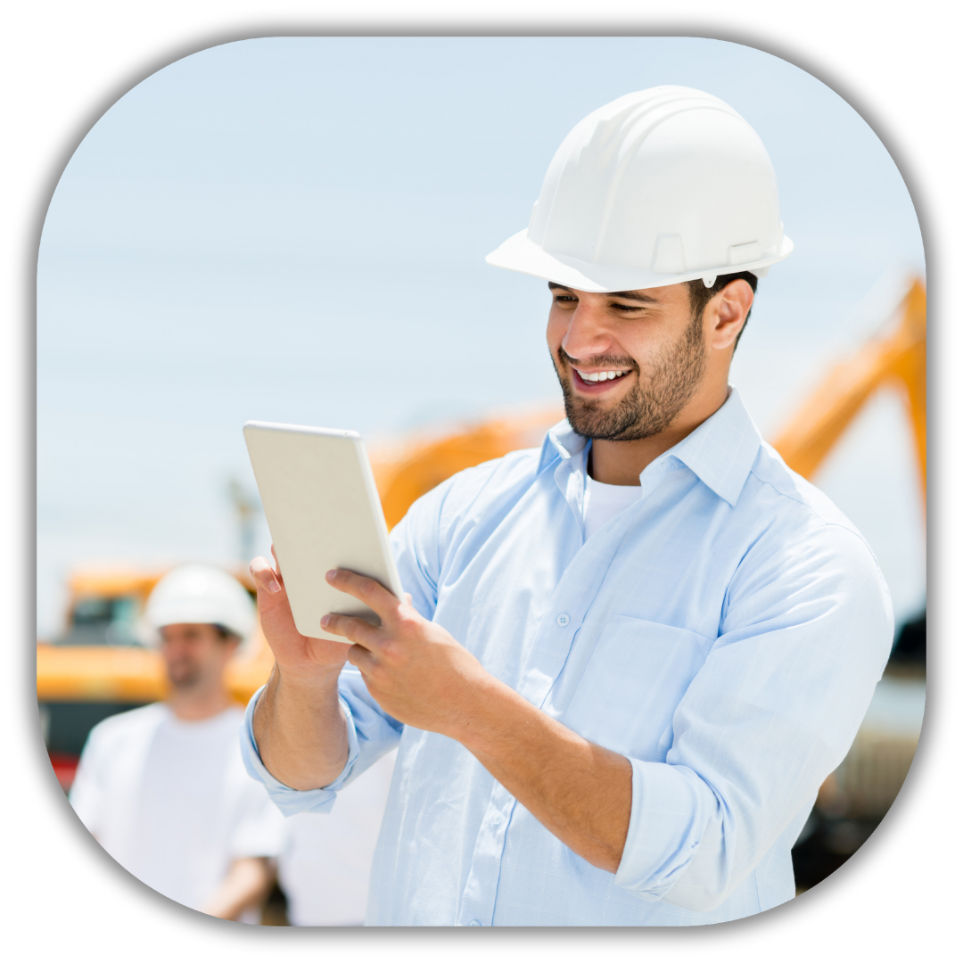 Smiling contractor in a white hard hat using a tablet at a construction site, illustrating streamlined business operations through customized software solutions for contractors to simplify tasks and improve efficiency.​⬤