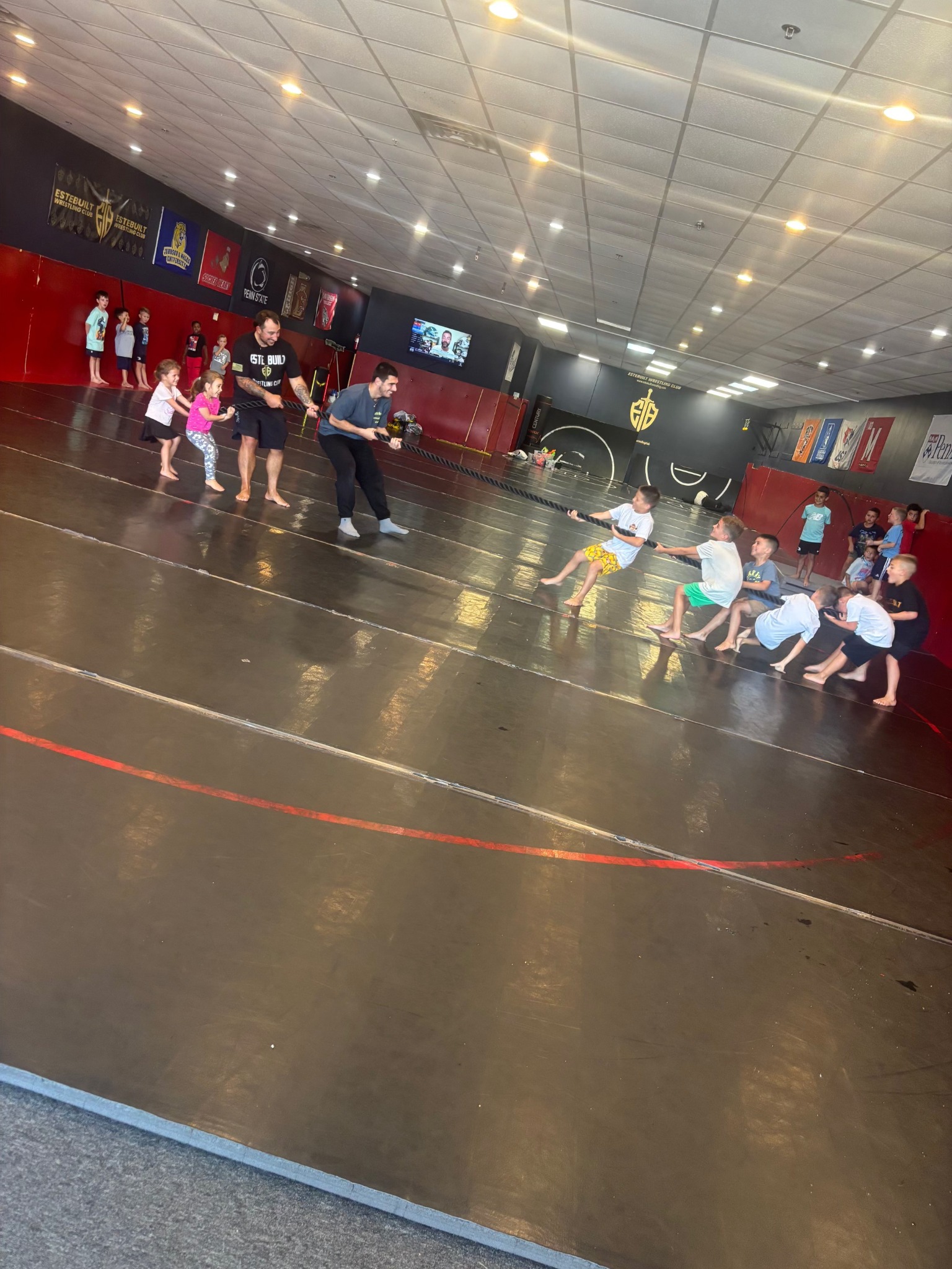 Kids playing tug-of-war with a coach at an Este Built birthday party