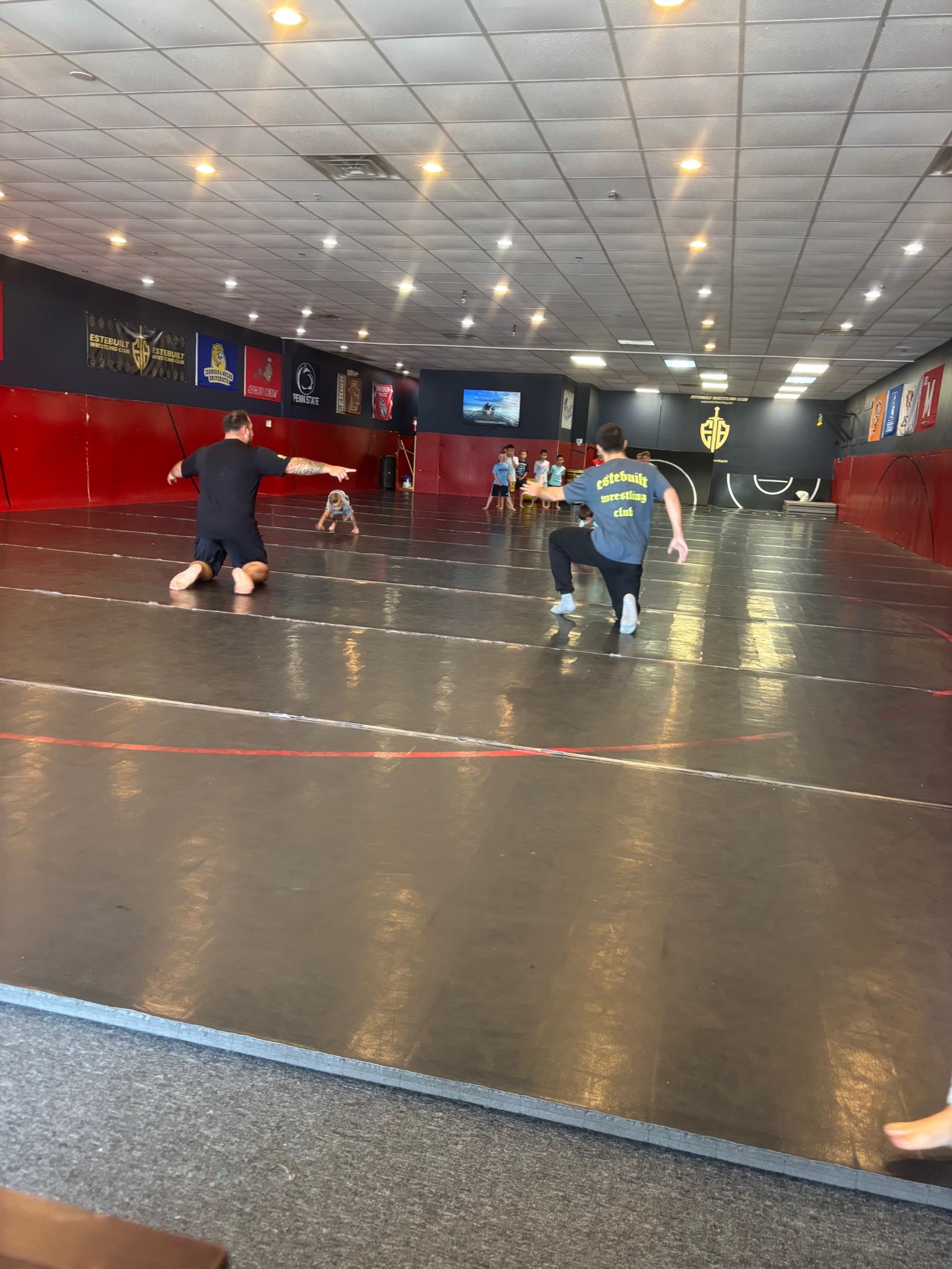 Coaches leading party games with children at Este Built Wrestling Club