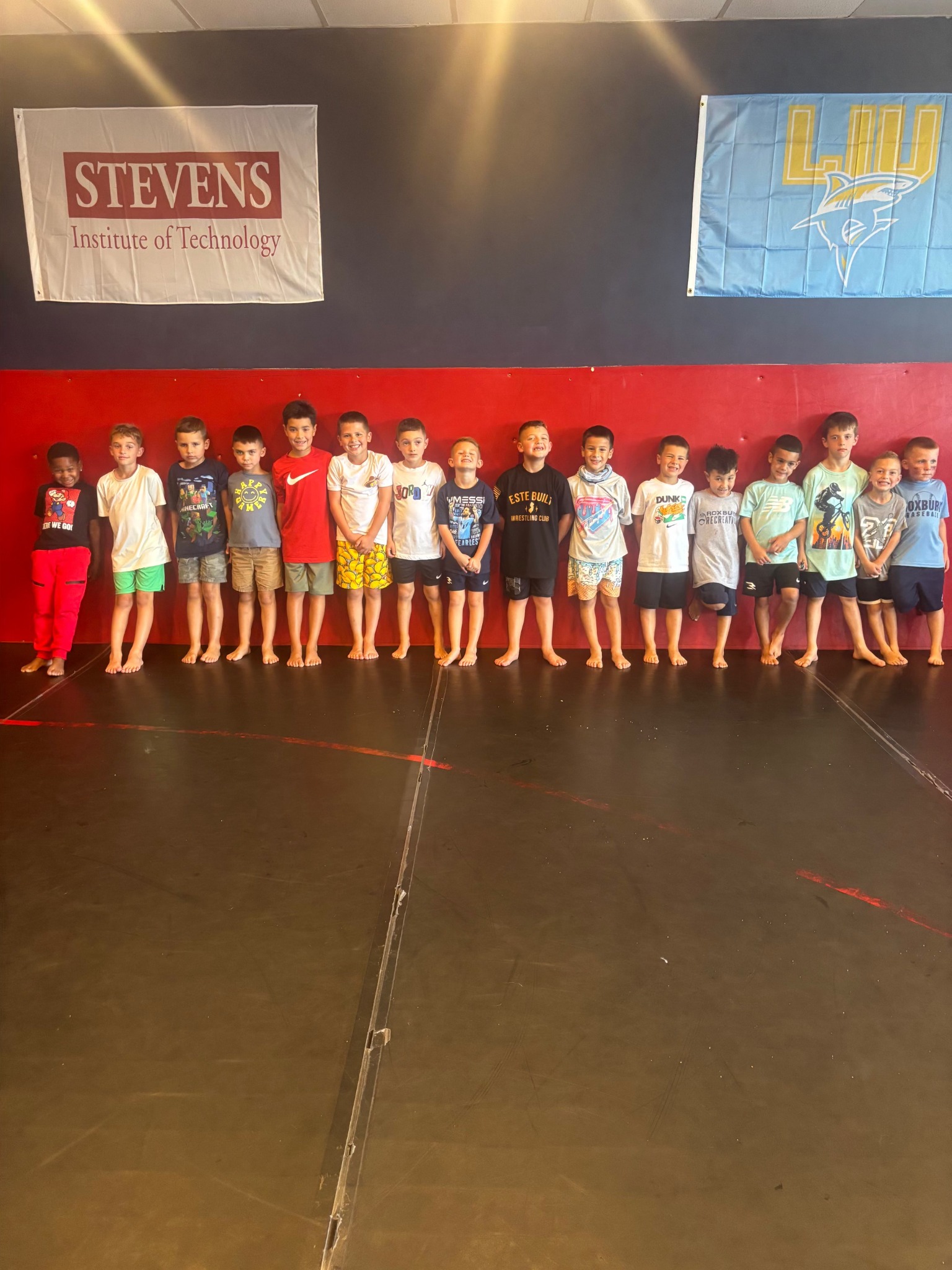 A line of young wrestlers in the Este Built gym during a Little Champs practice