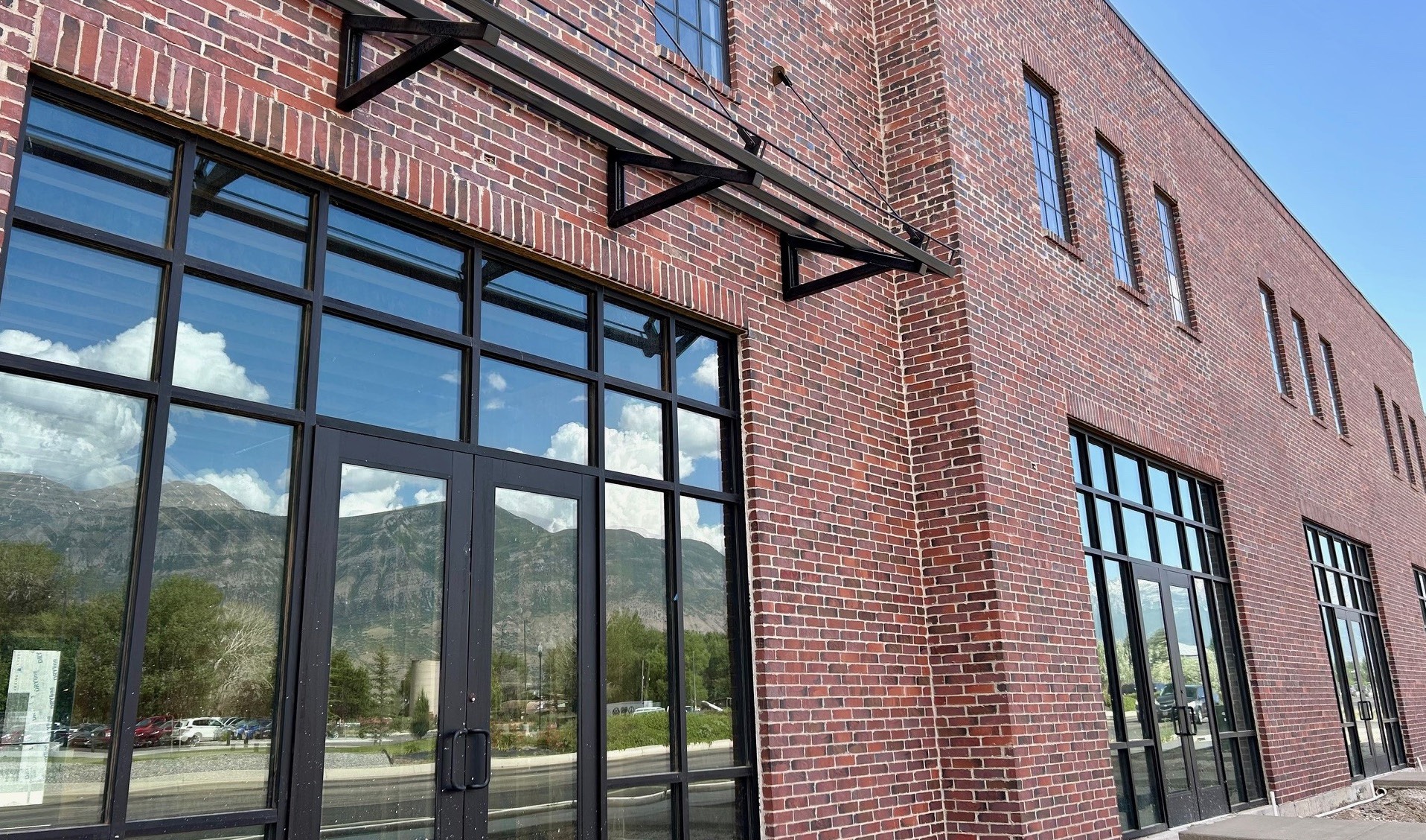 Brick storefront with the mountains reflected in its windows
