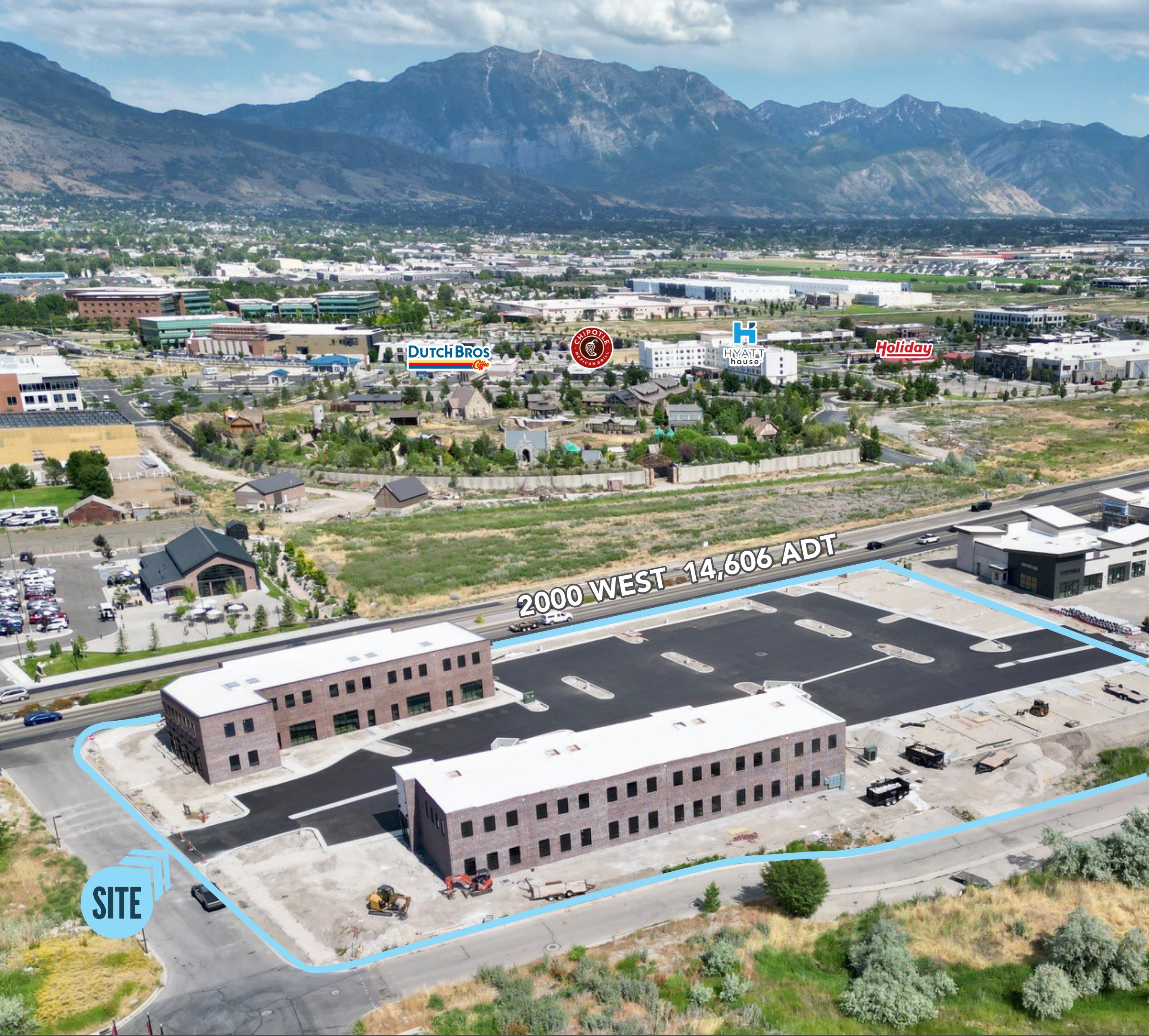 Aerial view of the Grove Cove site outlined on 2000 West, with the Wasatch mountains behind it