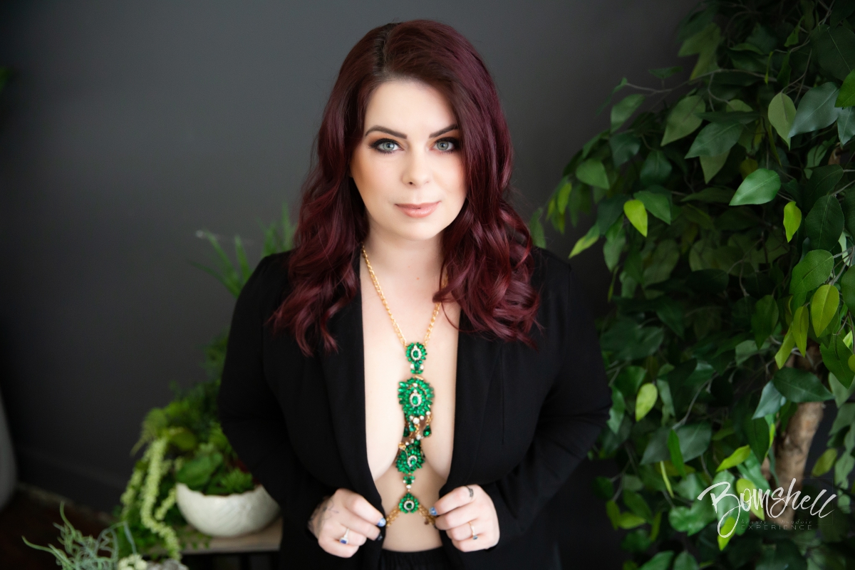 red-haired woman with green and gold necklace
