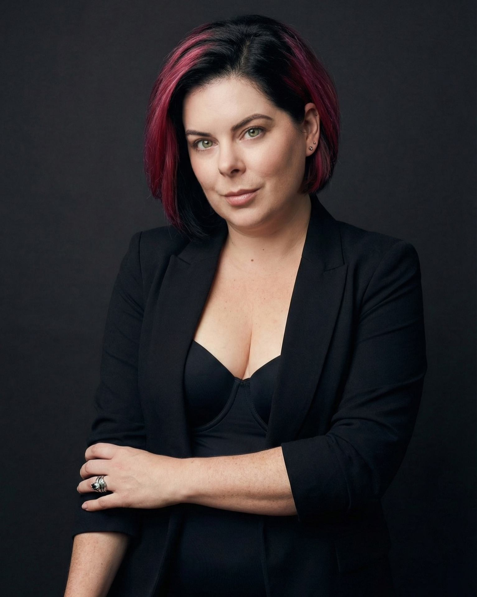 red-haired woman with green and gold necklace