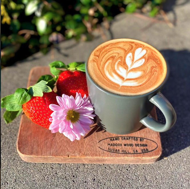 Small-batch latte with rosette latte art and fresh strawberries at Rushing Trading Co.