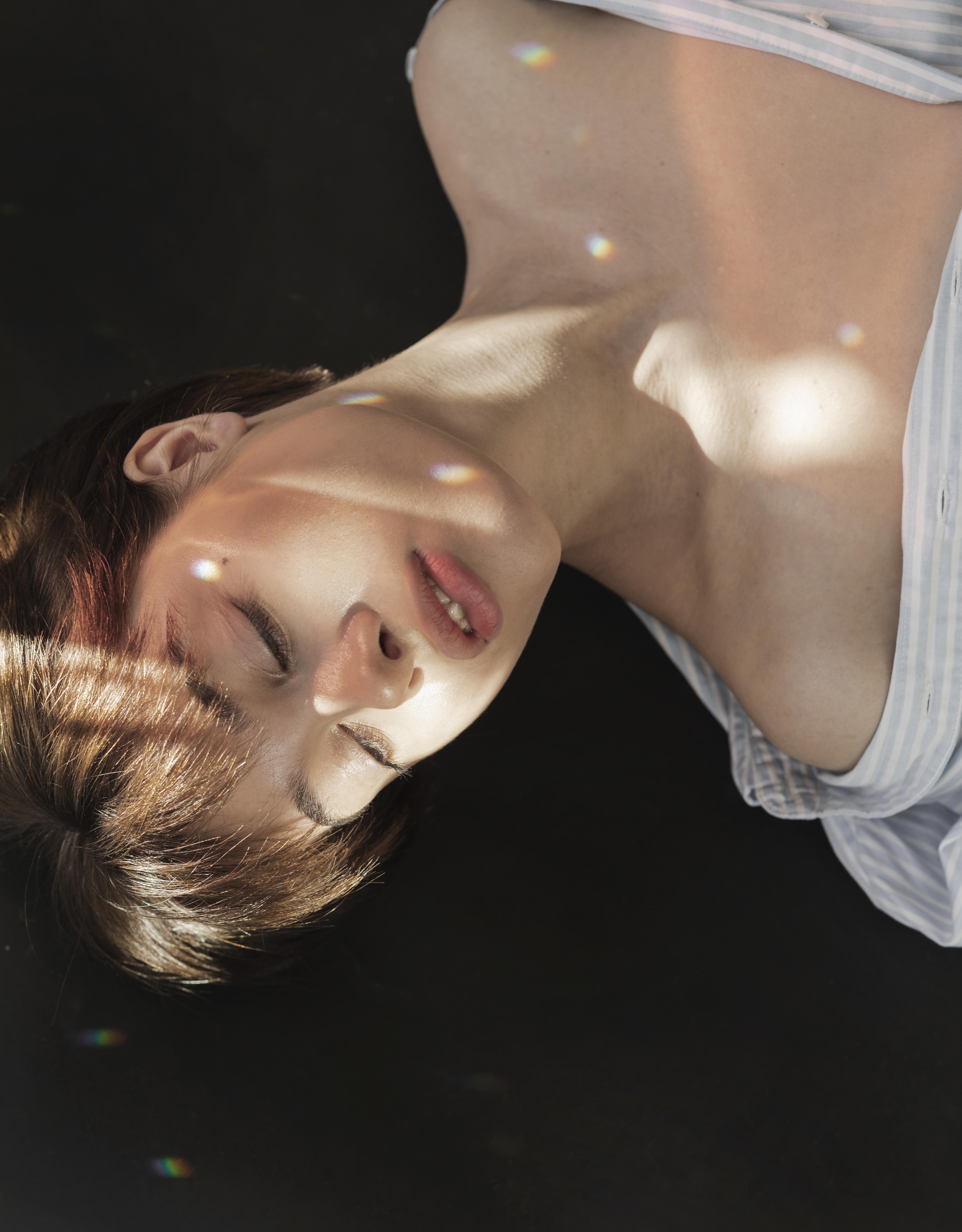 Relaxed woman lying on sofa with tranquil lighting during hypnotherapy session.