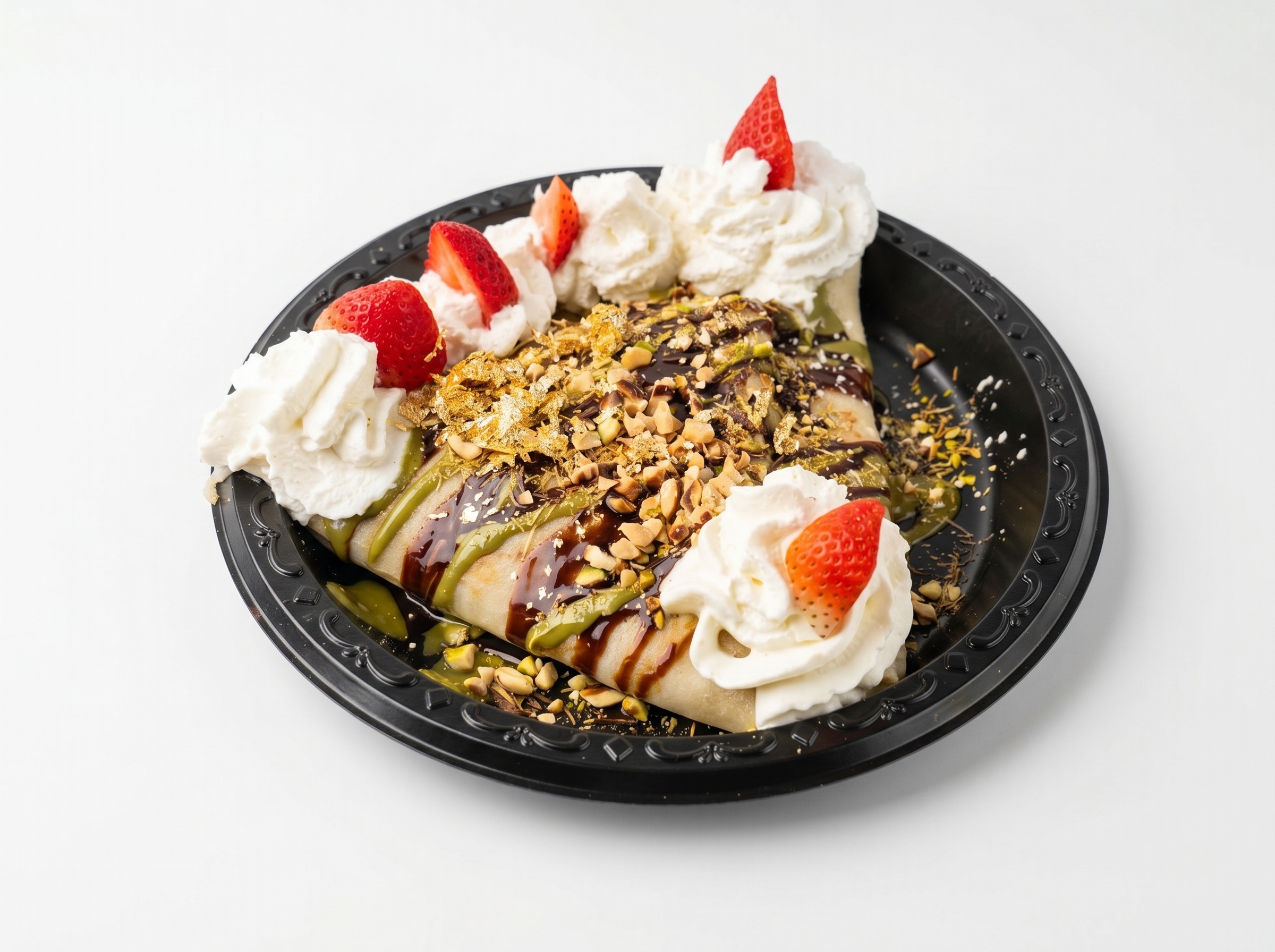 Dubai Dreams Crepe on ornate black plate — matcha base, pistachios, strawberries, chocolate drizzle, whipped cream