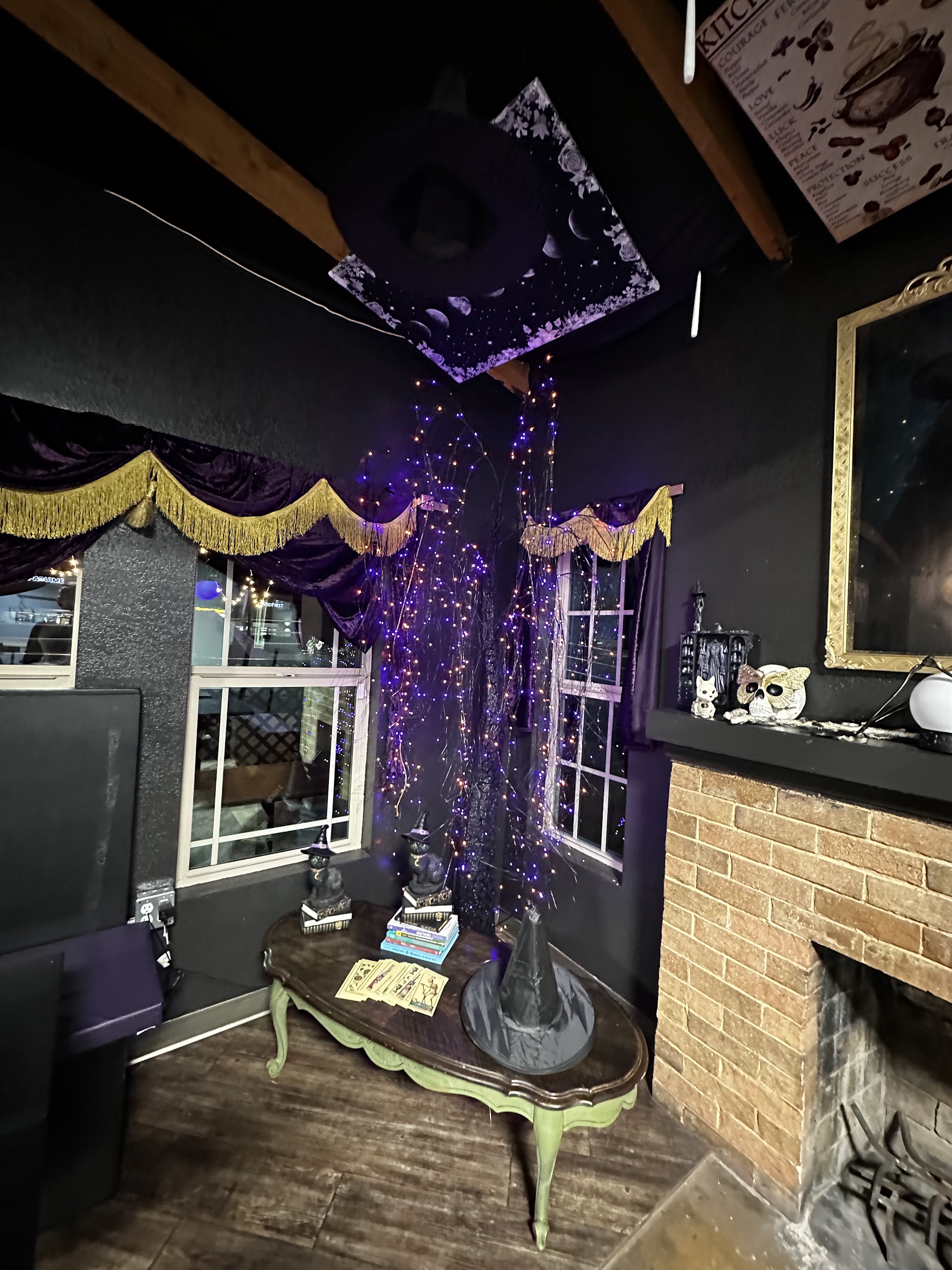 Fireplace nook with purple velvet drapes, gold fringe, and fairy light tree