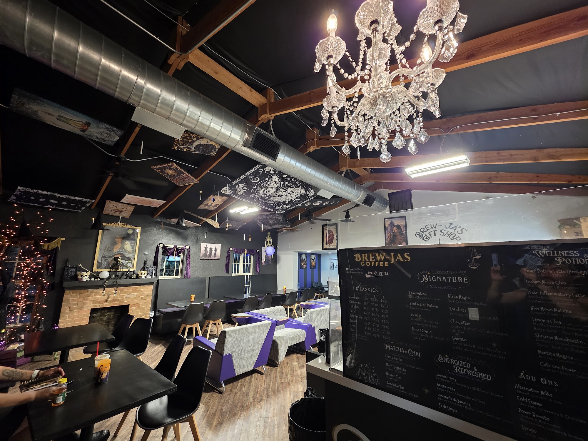 Brew-Ja's Coffee interior panoramic — chandelier, chalkboard menu, fireplace, fairy lights, Gift Shop sign