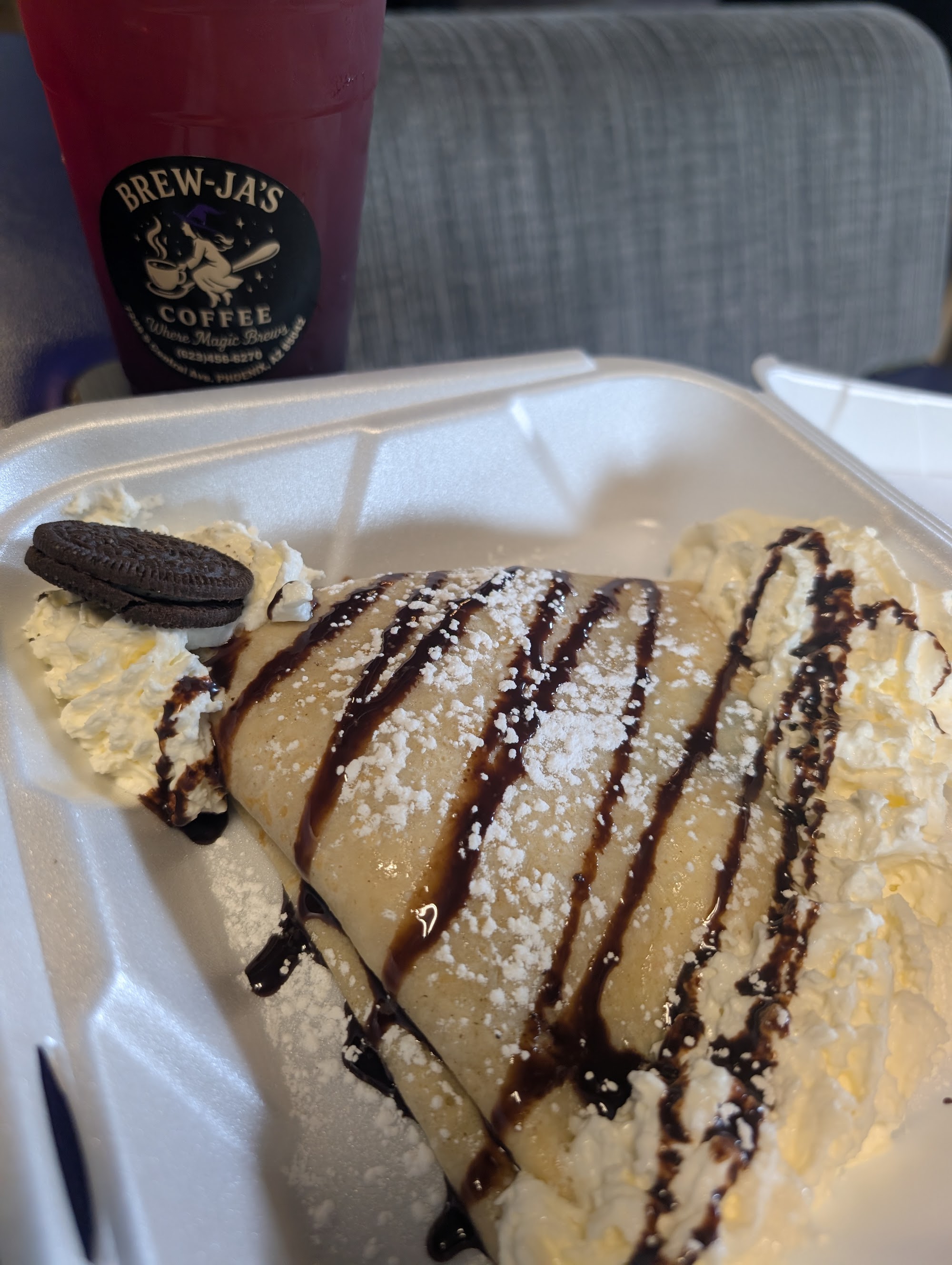 Chocolate crepe in clamshell with Oreo and branded berry drink in background