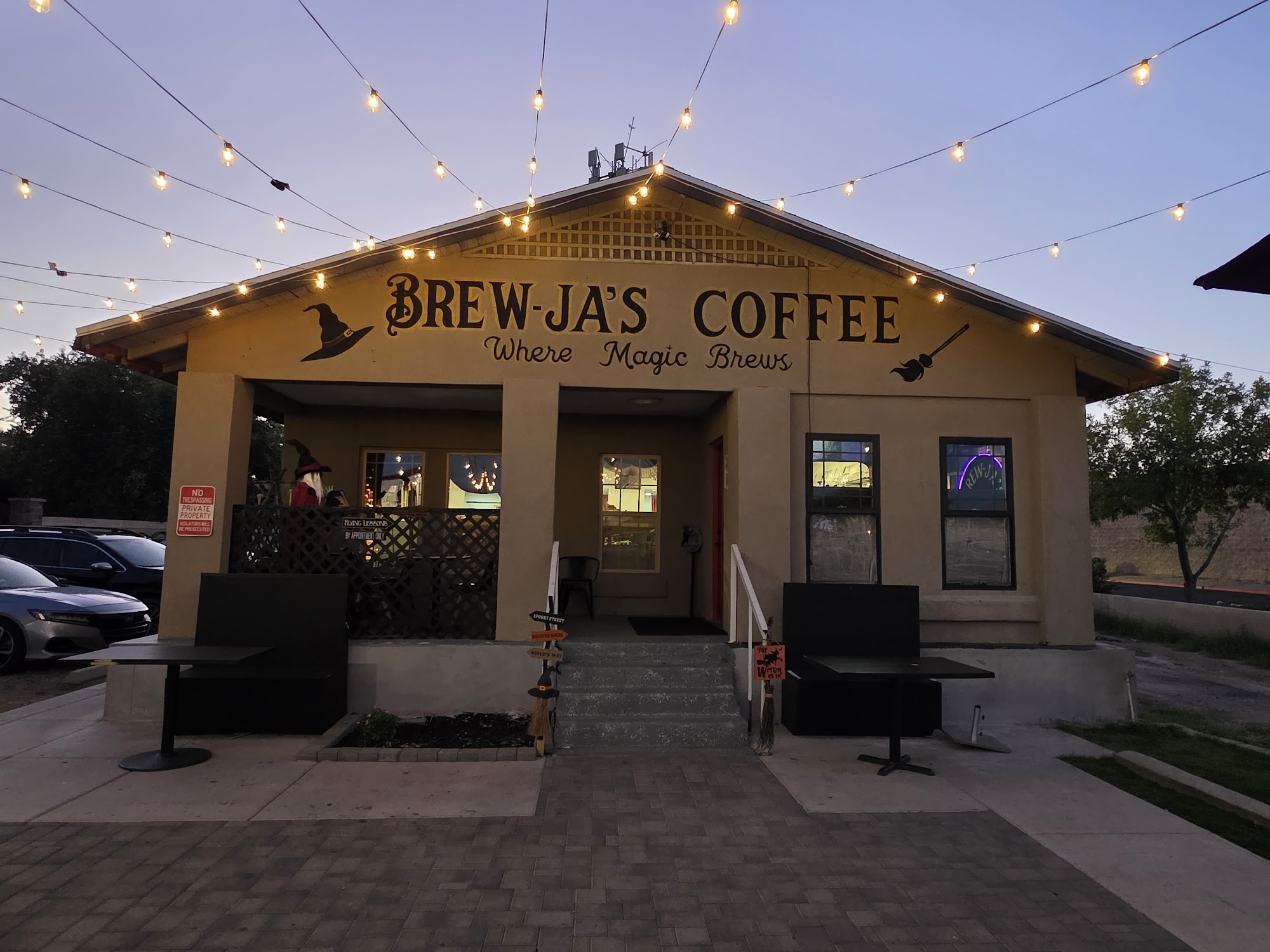 Brew-Ja's Coffee exterior at dusk — string lights glowing, outdoor patio seating, South Phoenix