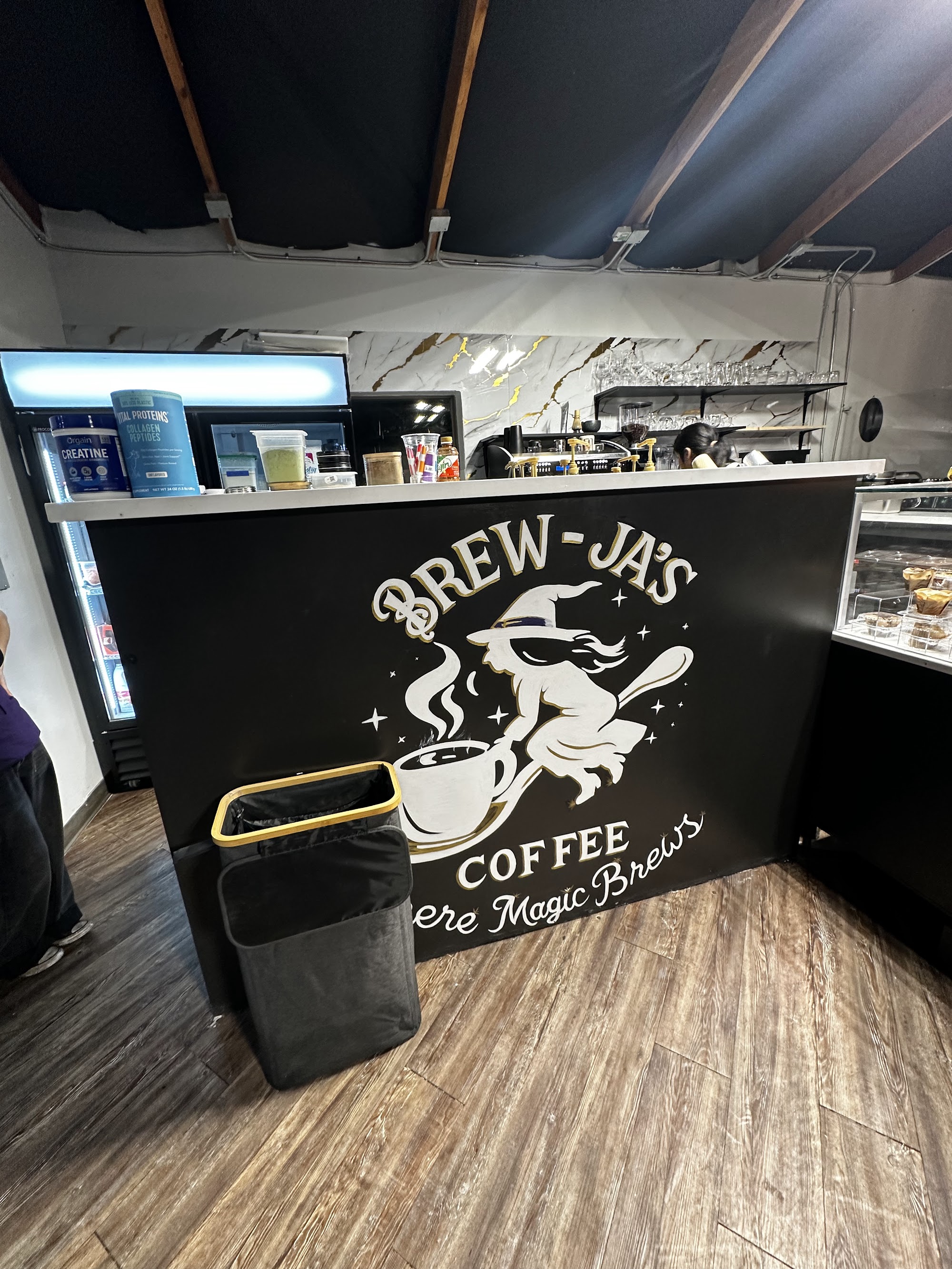 Brew-Ja's Coffee counter with Where Magic Brews logo panel and barista area