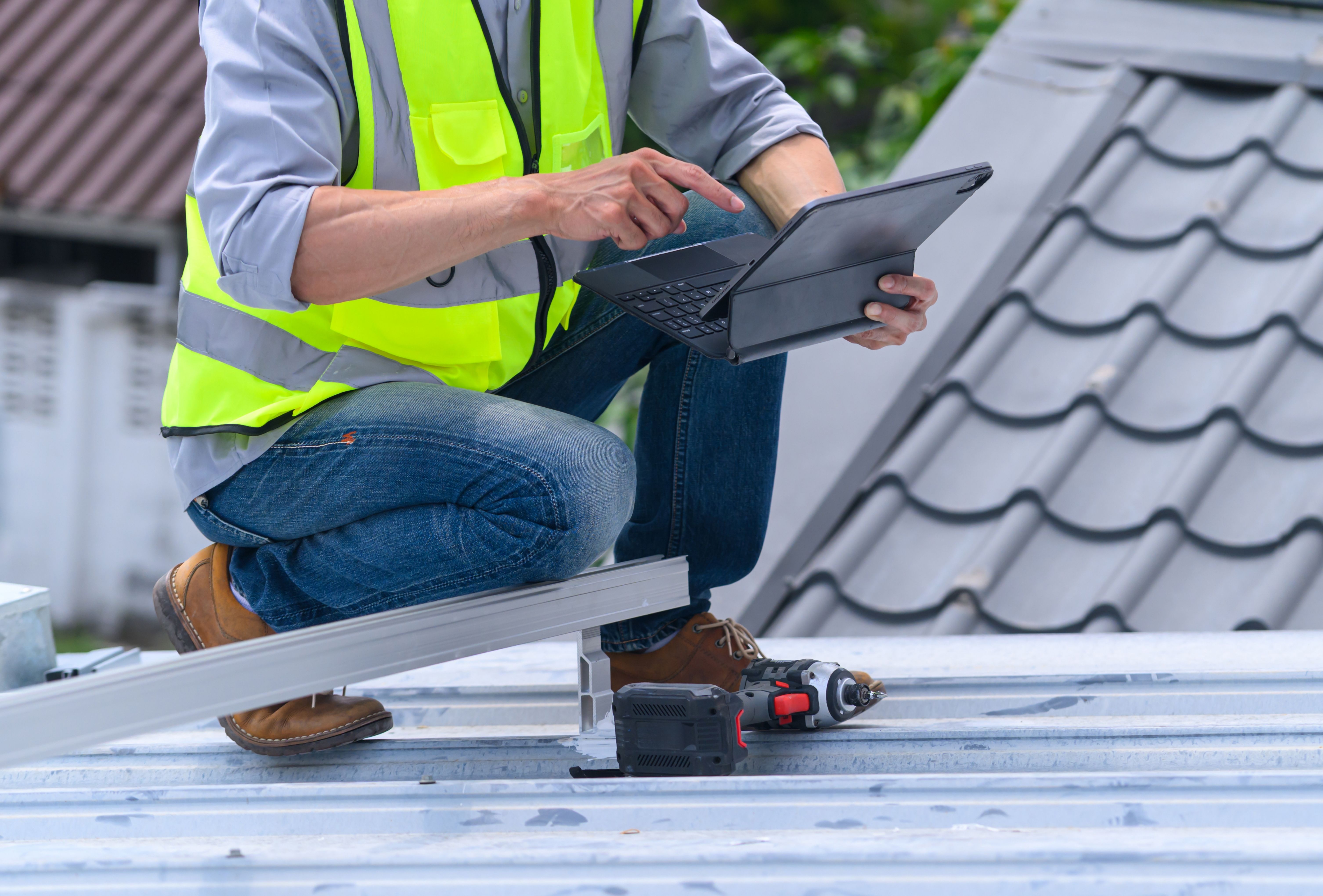 A contractor showing tablet assessment results to a homeowner for roof maintenance Wisconsin. A contractor showing tablet assessment results to a homeowner for roof maintenance Wisconsin.