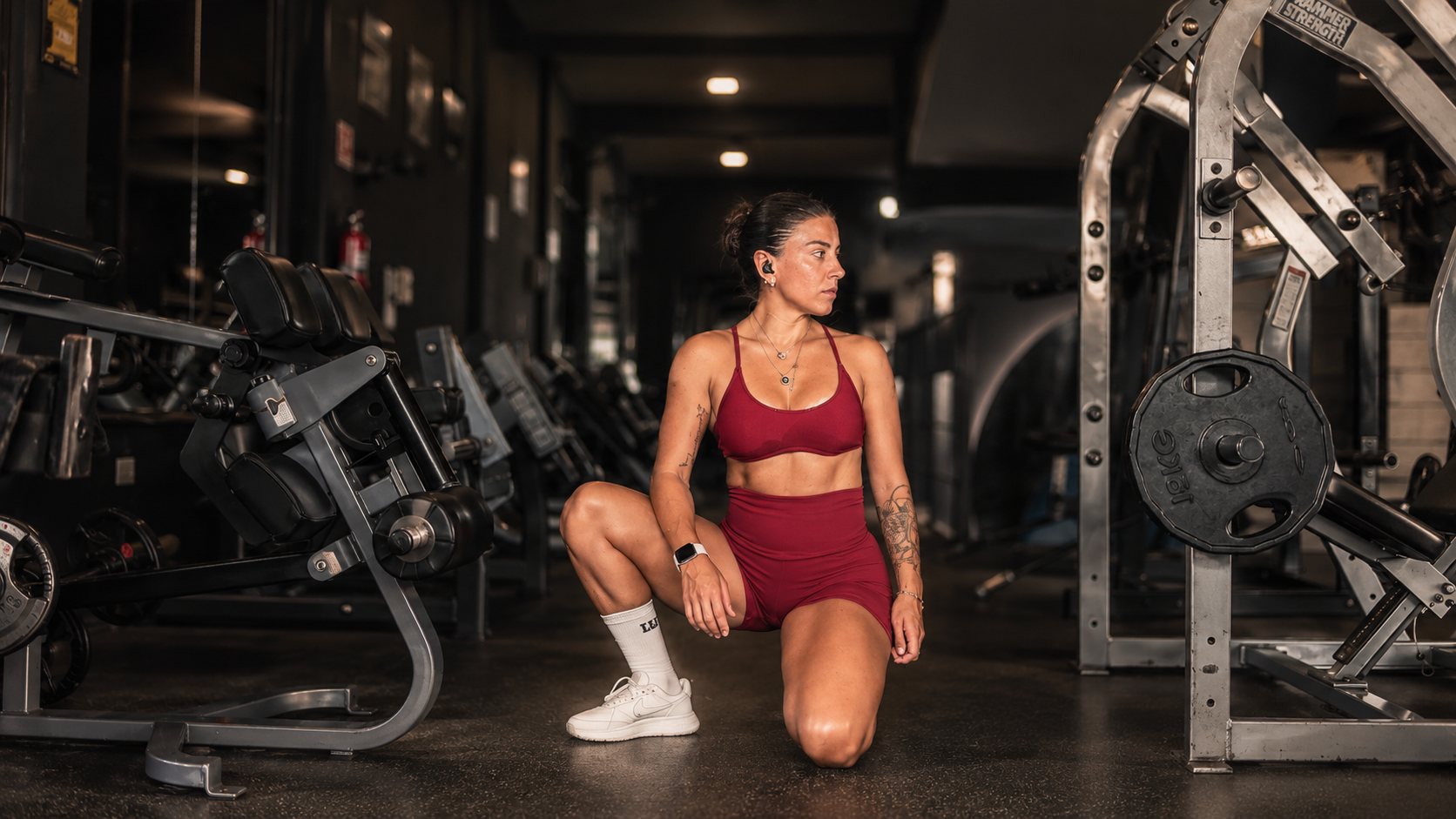 Ignacia Briones arrodillada en el gimnasio, mirando hacia un lado