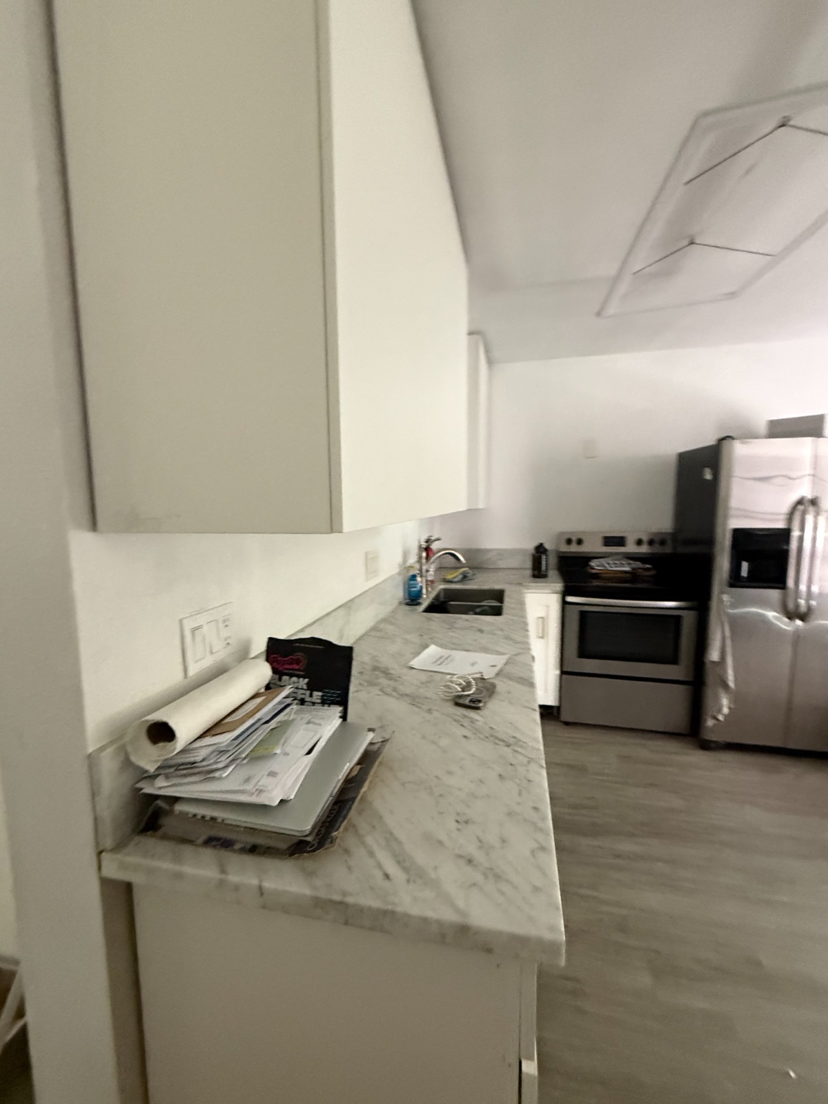 After — Renovated kitchen with marble counters and modern appliances completed by Astra Home Buyer team