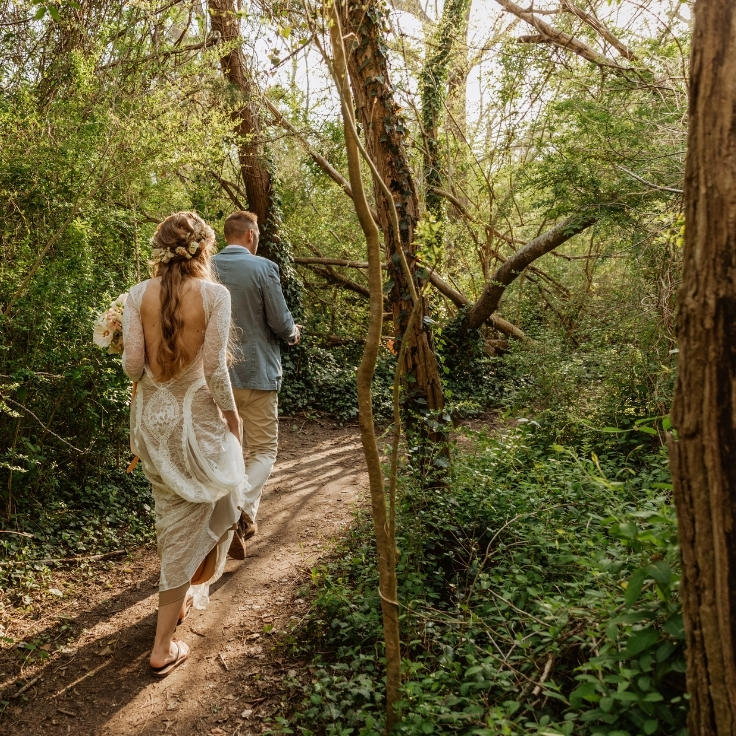 couple walking through sandy forest to sand dune ceremony during Cape May elopement couple walking through sandy forest to sand dune ceremony during Cape May elopement