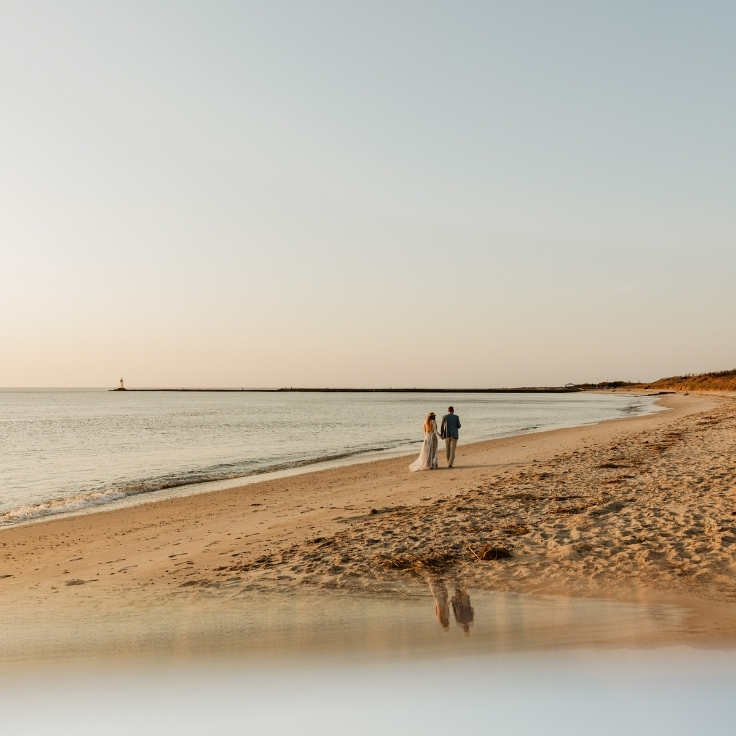 couple walking along Cape May beach at sunset heading to picnic elopement setup couple walking along Cape May beach at sunset heading to picnic elopement setup