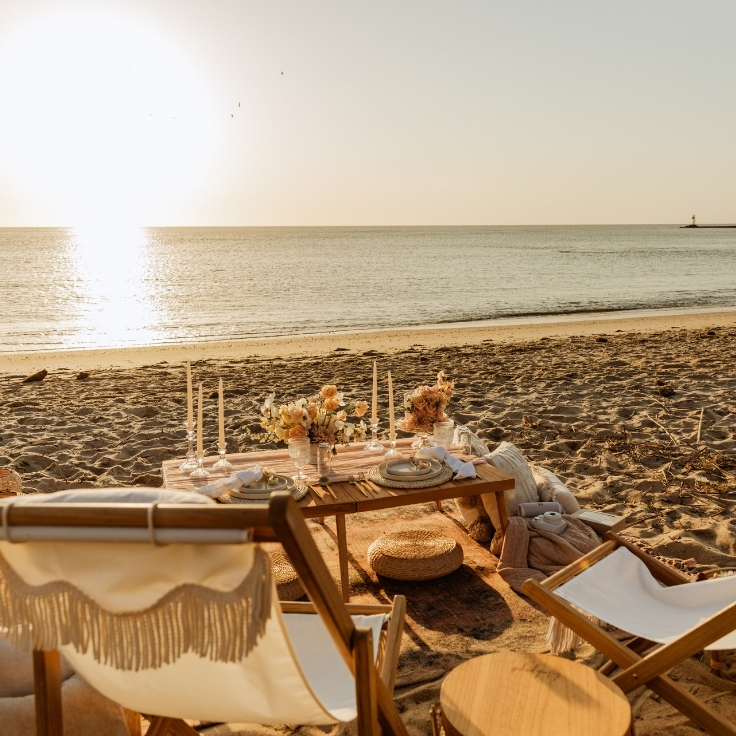 cozy beach picnic setup with cake, florals, and fire pit during Cape May sunset elopement cozy beach picnic setup with cake, florals, and fire pit during Cape May sunset elopement