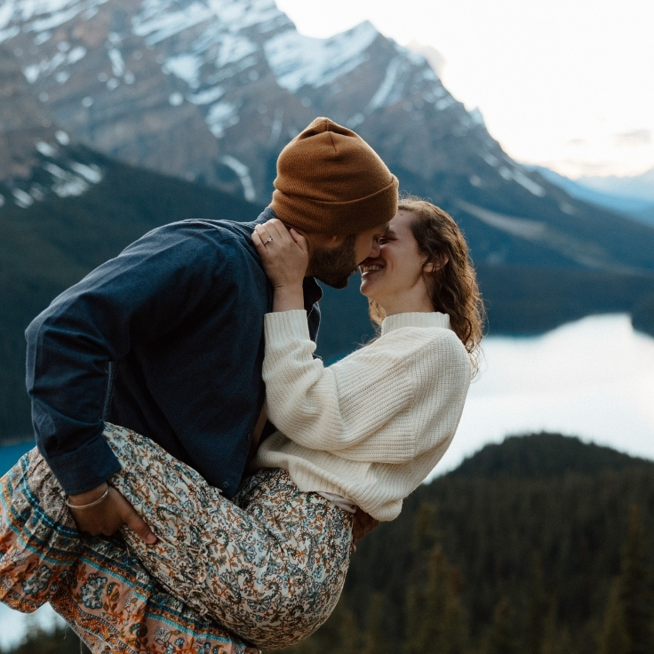 Couple dancing at a scenic mountain overlook above Peyto Lake with dramatic alpine views during a cinematic Banff engagement session.
