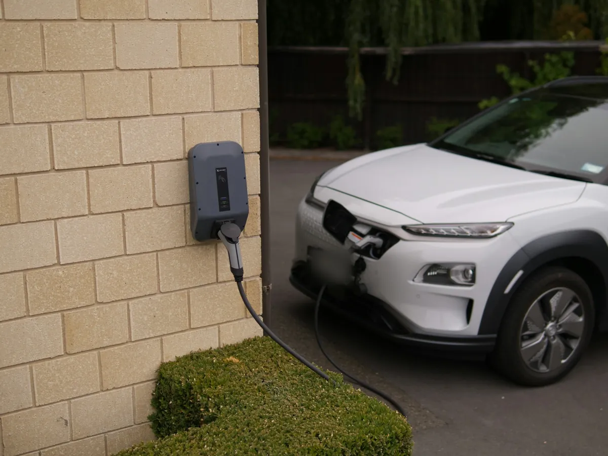 Home EV charger on a stone wall, charging a car