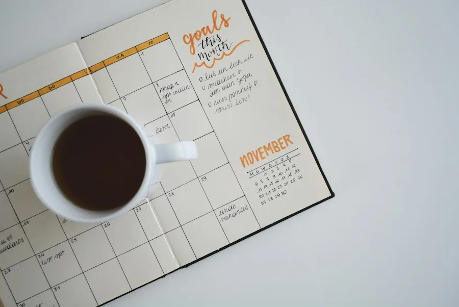 Paper planner open on a desk with a pen, a month of mostly empty days