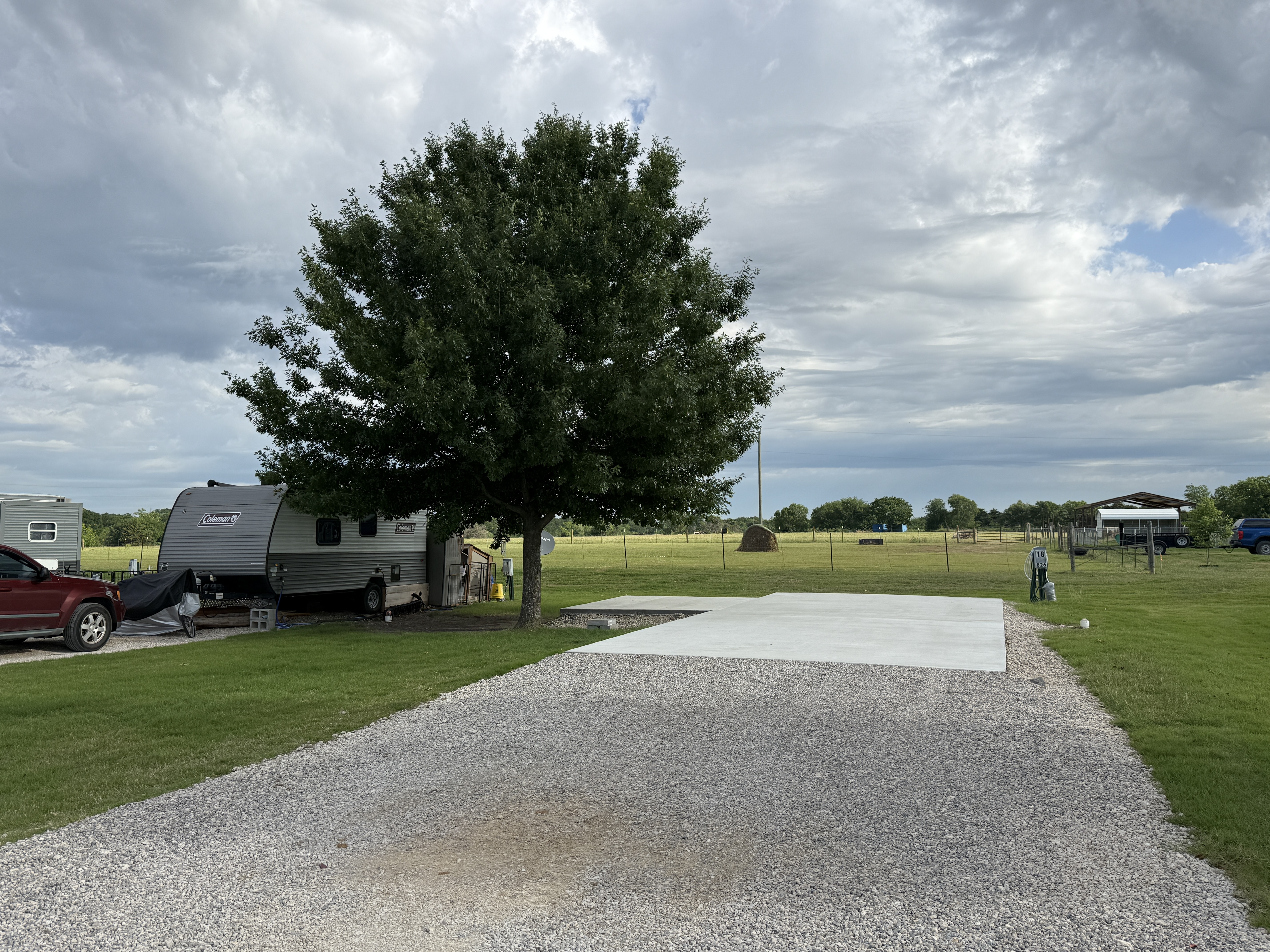 Available concrete Patio Site with shade tree and open ranch land behind