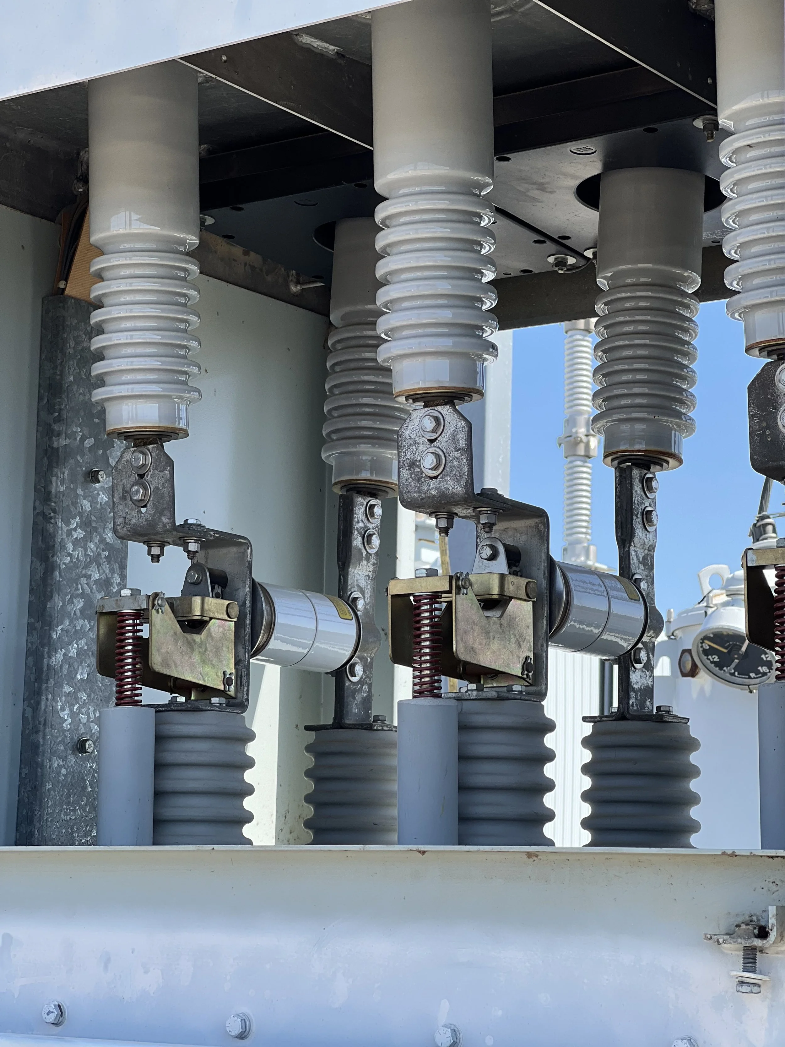 Close-up of circuit breaker bushings and insulator assembly