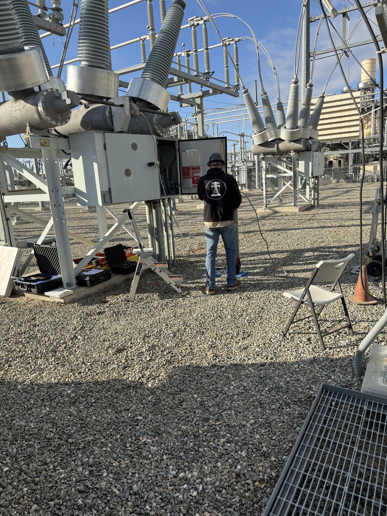 Trained technician performing diagnostic work on high-voltage substation equipment