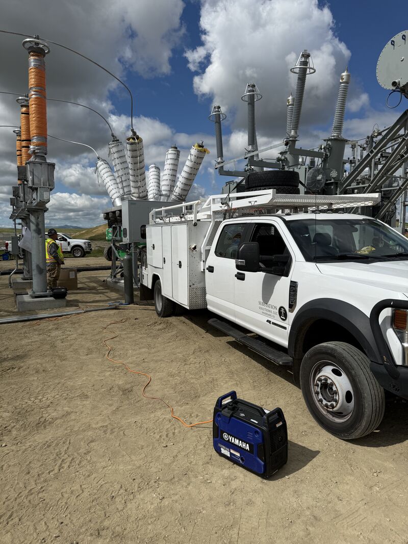 Substation service truck positioned next to high-voltage equipment during maintenance work