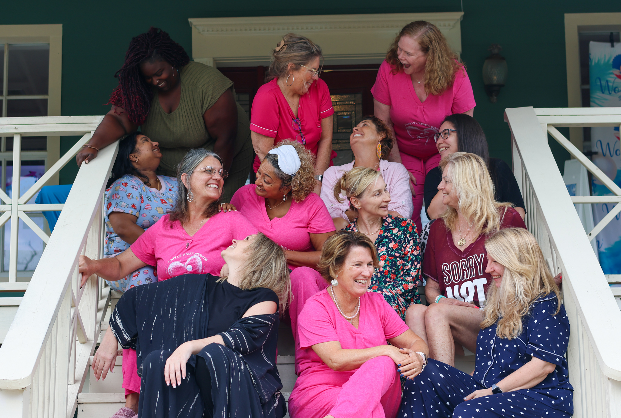 Women with Coach Pearl sitting on steps smiling after releasing their inner SHERO
