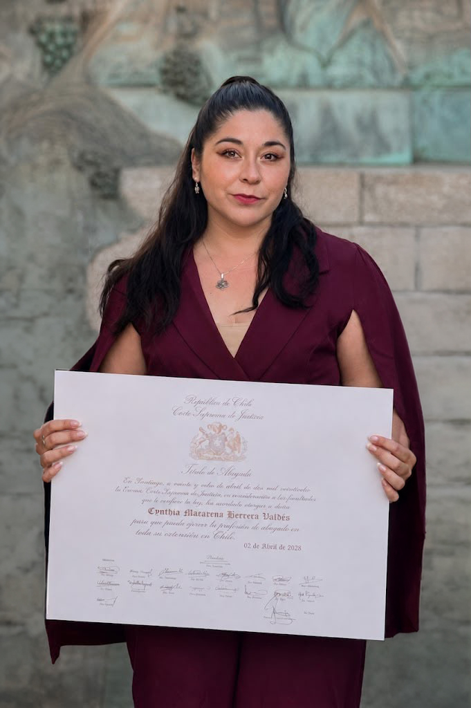 Cynthia Herrera Valdés sosteniendo su título de abogada otorgado por la Corte Suprema de Justicia de Chile