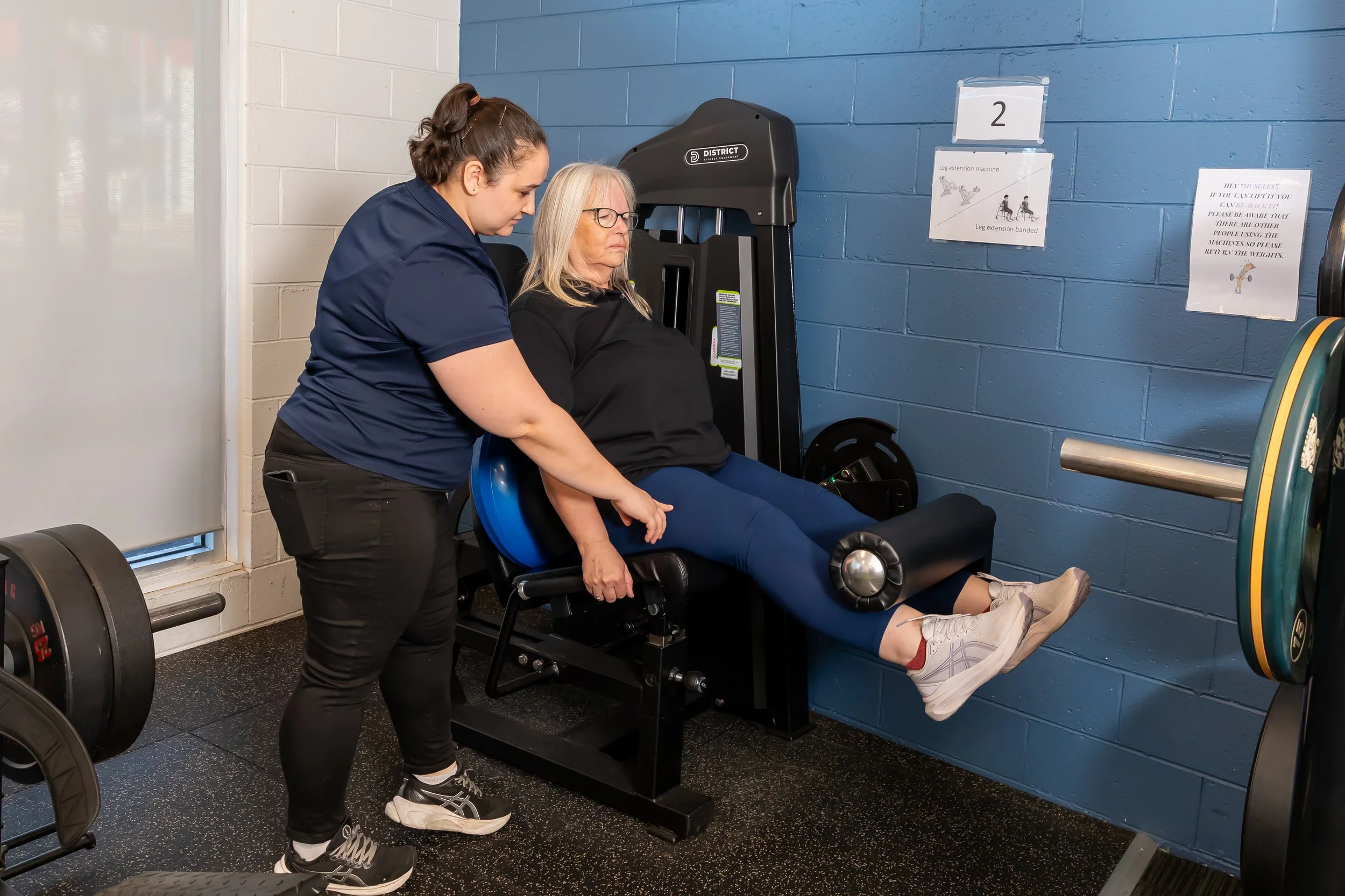Physiotherapist assisting a patient with leg strengthening exercises