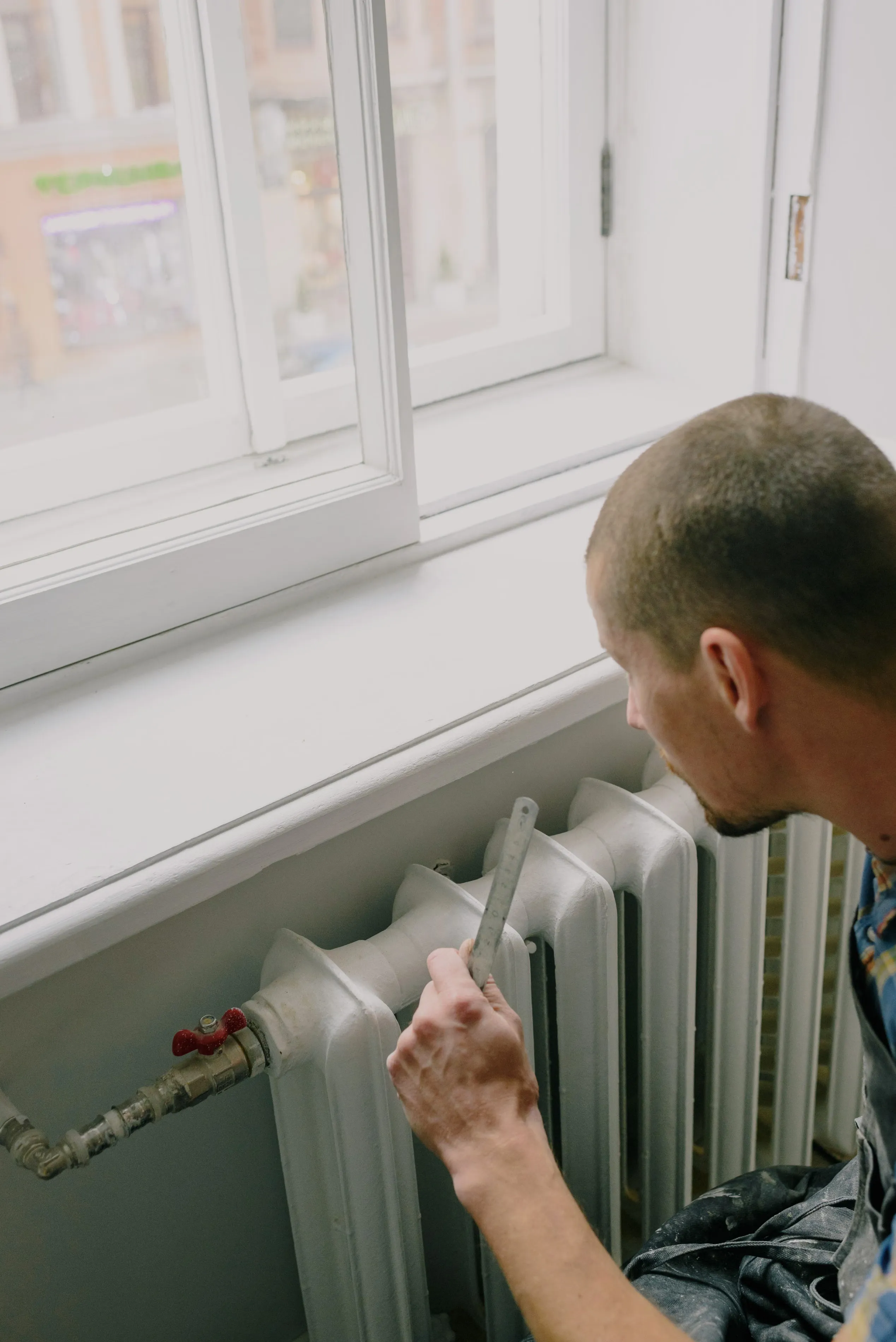 A worker measuring near a home heating and plumbing system