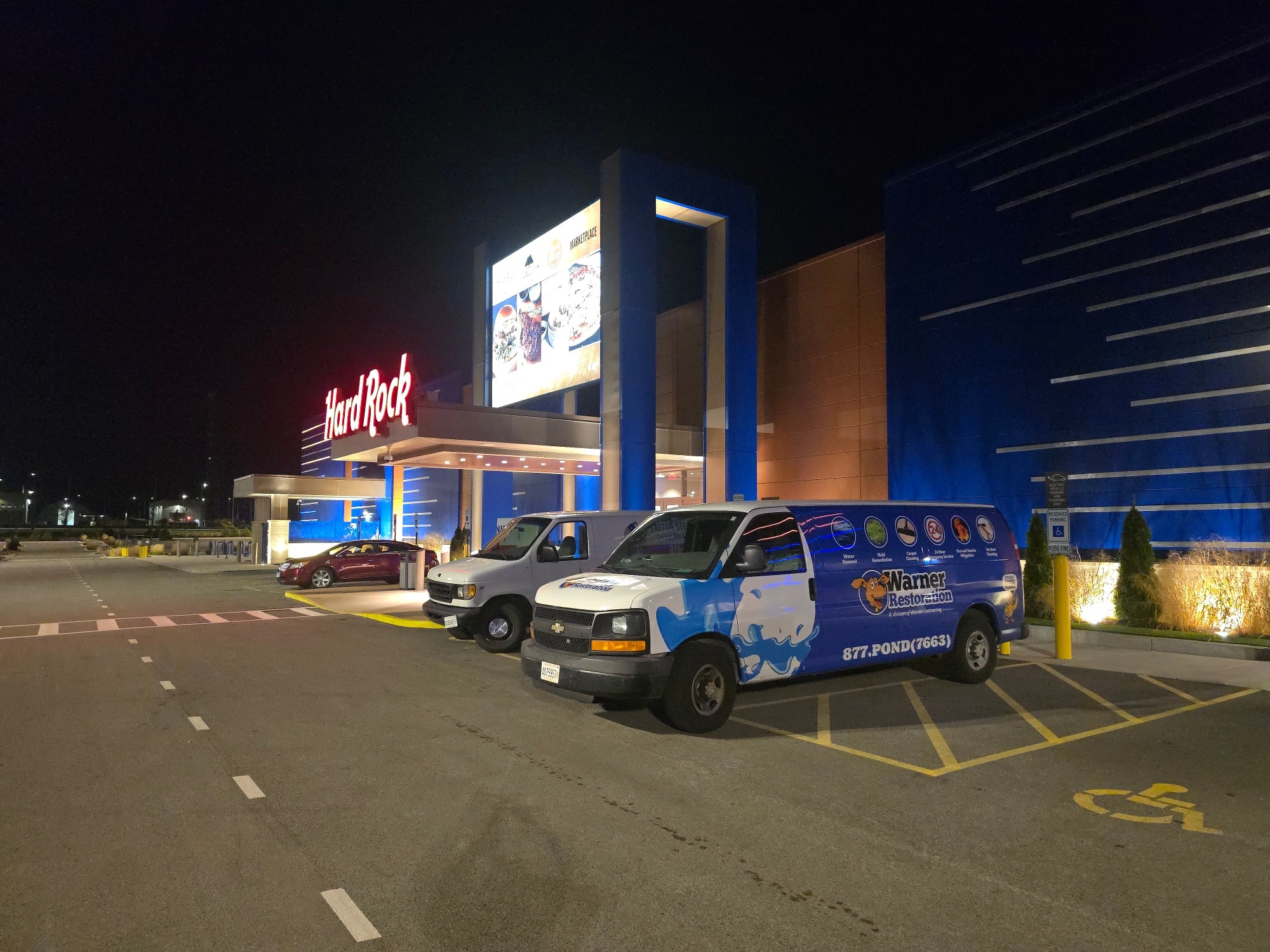 Warner Restoration service vans parked at Hard Rock Casino during nighttime commercial job