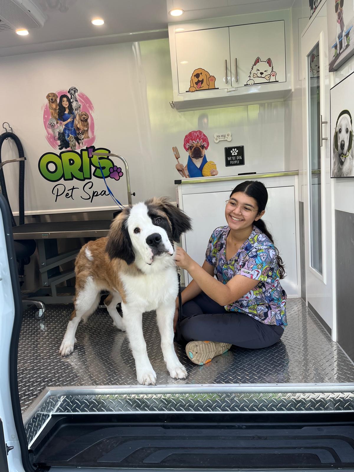 Mobile groomer with a dog inside the Ori's Pet Spa grooming van.