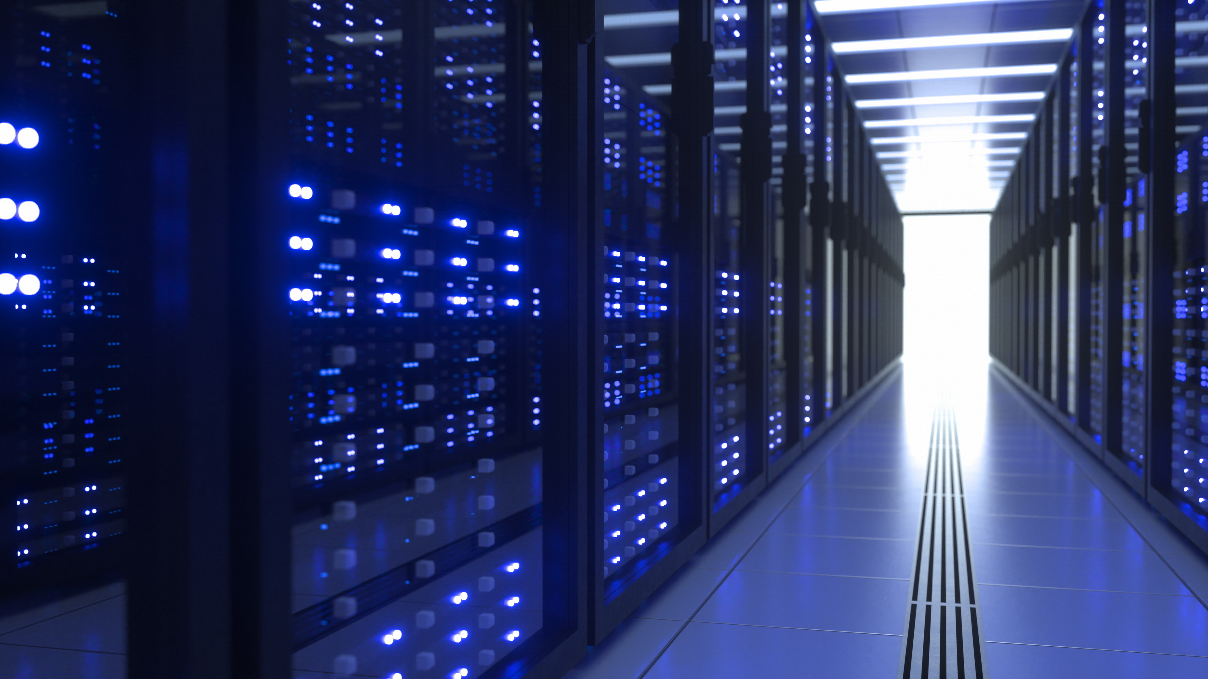 Rows of illuminated server racks inside a modern data center, representing data center development in DeKalb County. For more information about the county's ongoing work related to data centers, visit the Engage DeKalb website at EngageDeKalb.DeKalbCountyGA.gov.