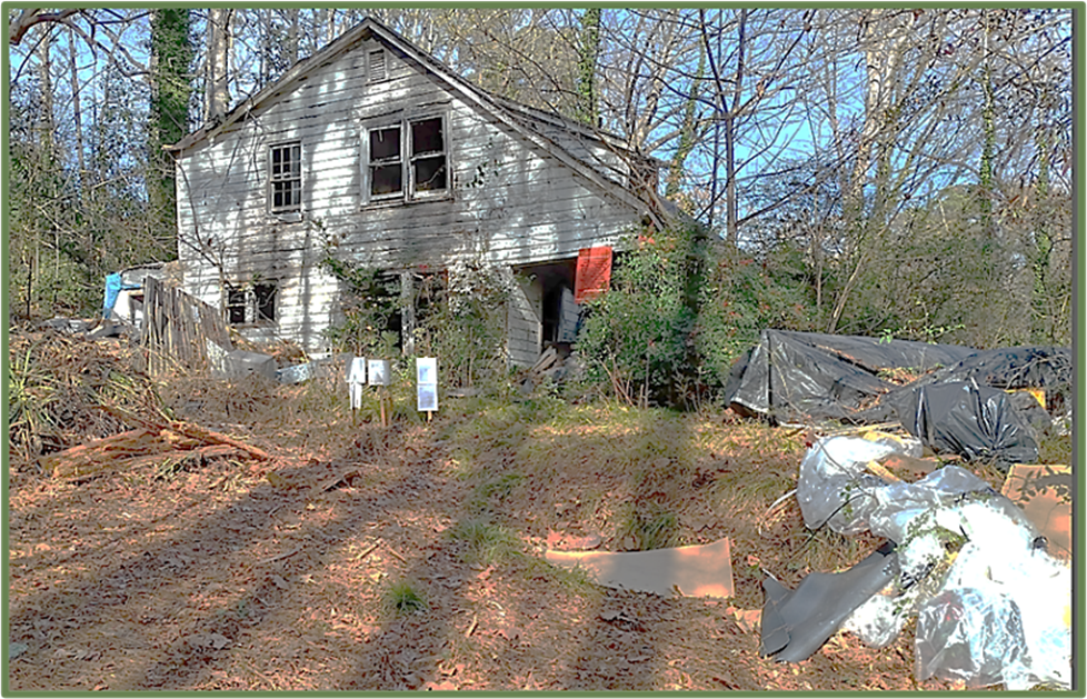 Severely blighted home at 666 Sheppard Road with broken windows, overgrowth, and debris covering the lot prior to demolition and cleanup.