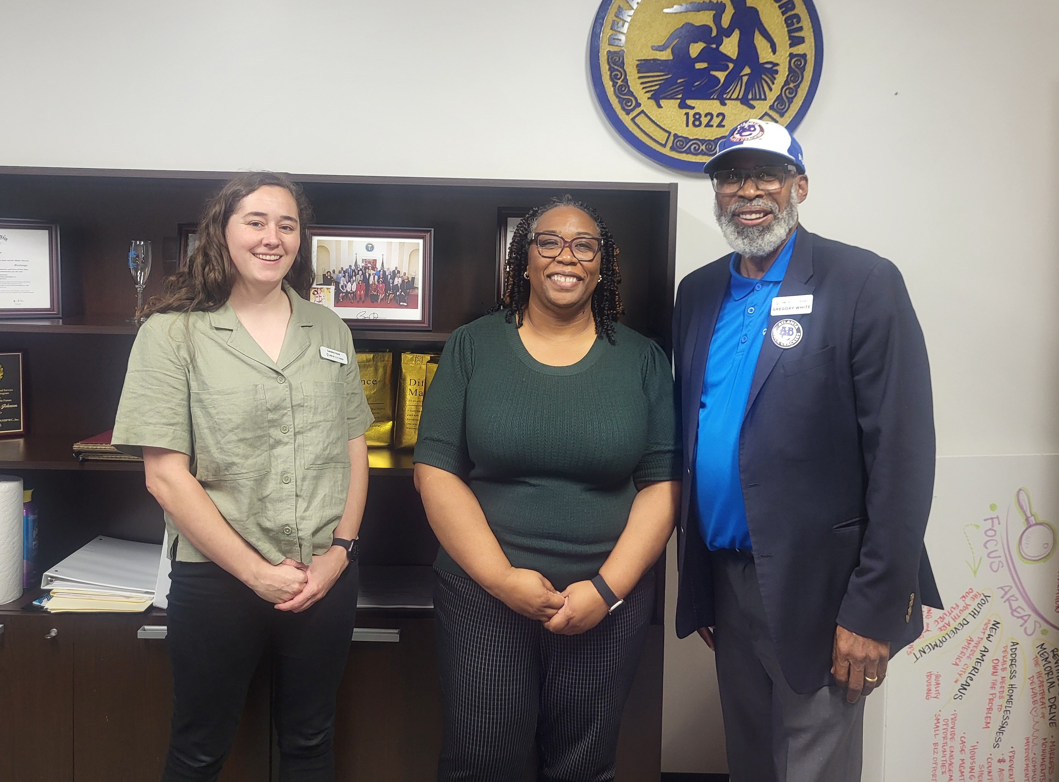 Commissioner Chakira Johnson poses for a photo in her office with Caroline Hurst and Greg White of A Home for Everyone in DeKalb following a meeting about housing and community support initiatives.