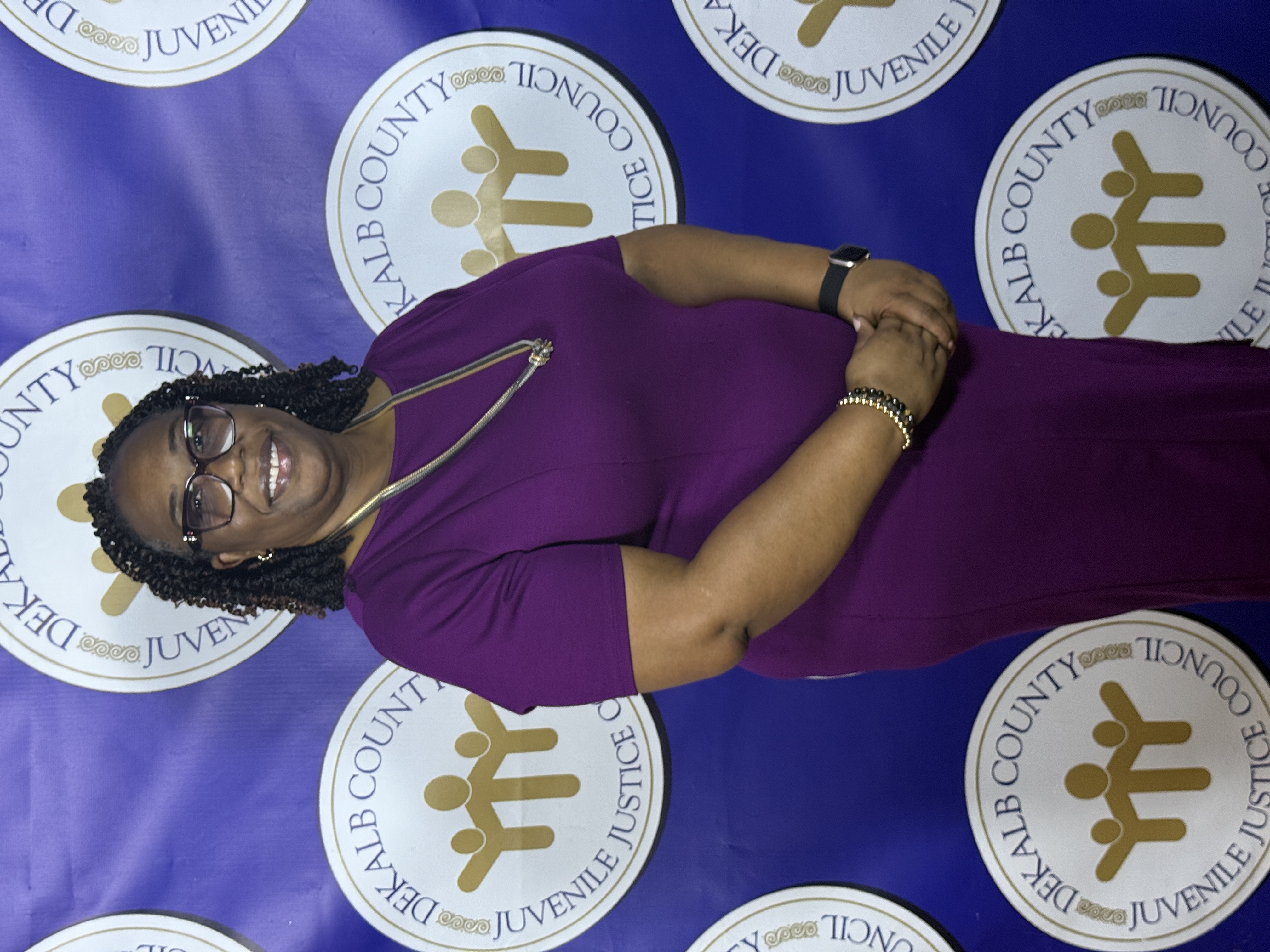 Commissioner Chakira Johnson poses for a portrait in front of a DeKalb County Juvenile Justice Council step-and-repeat backdrop during the organization's gala celebration.