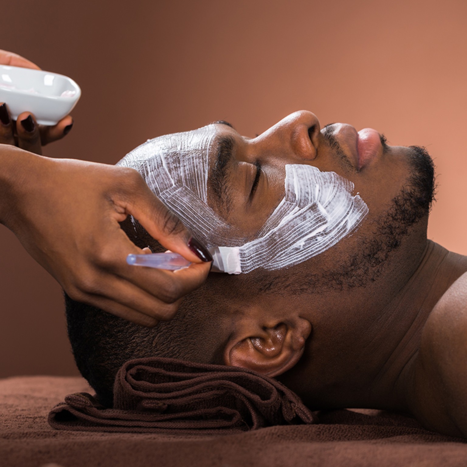 A Black man receiving a personalized facial treatment