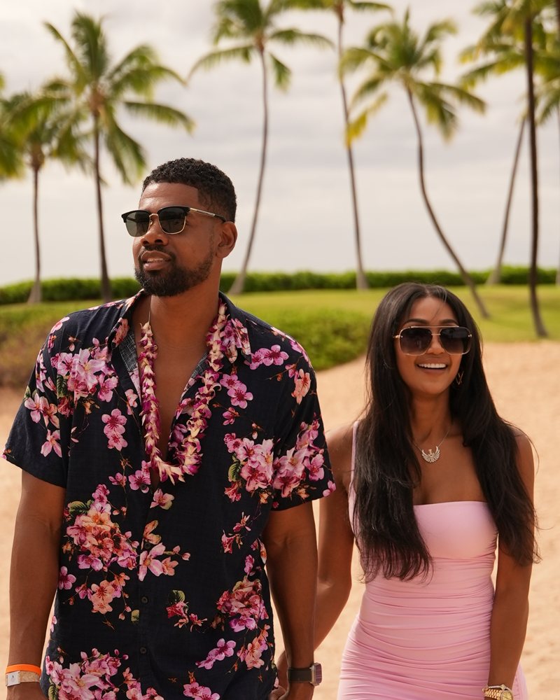 Brock and his wife walking on the beach in matching resort outfits