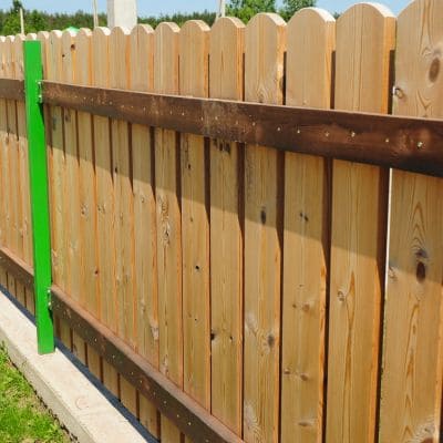 Wooden privacy fence with green and brown support posts