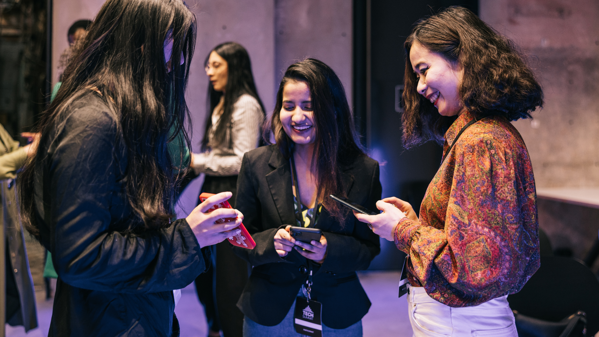 People exchanging contact details on their phones at a networking event People exchanging contact details on their phones at a networking event