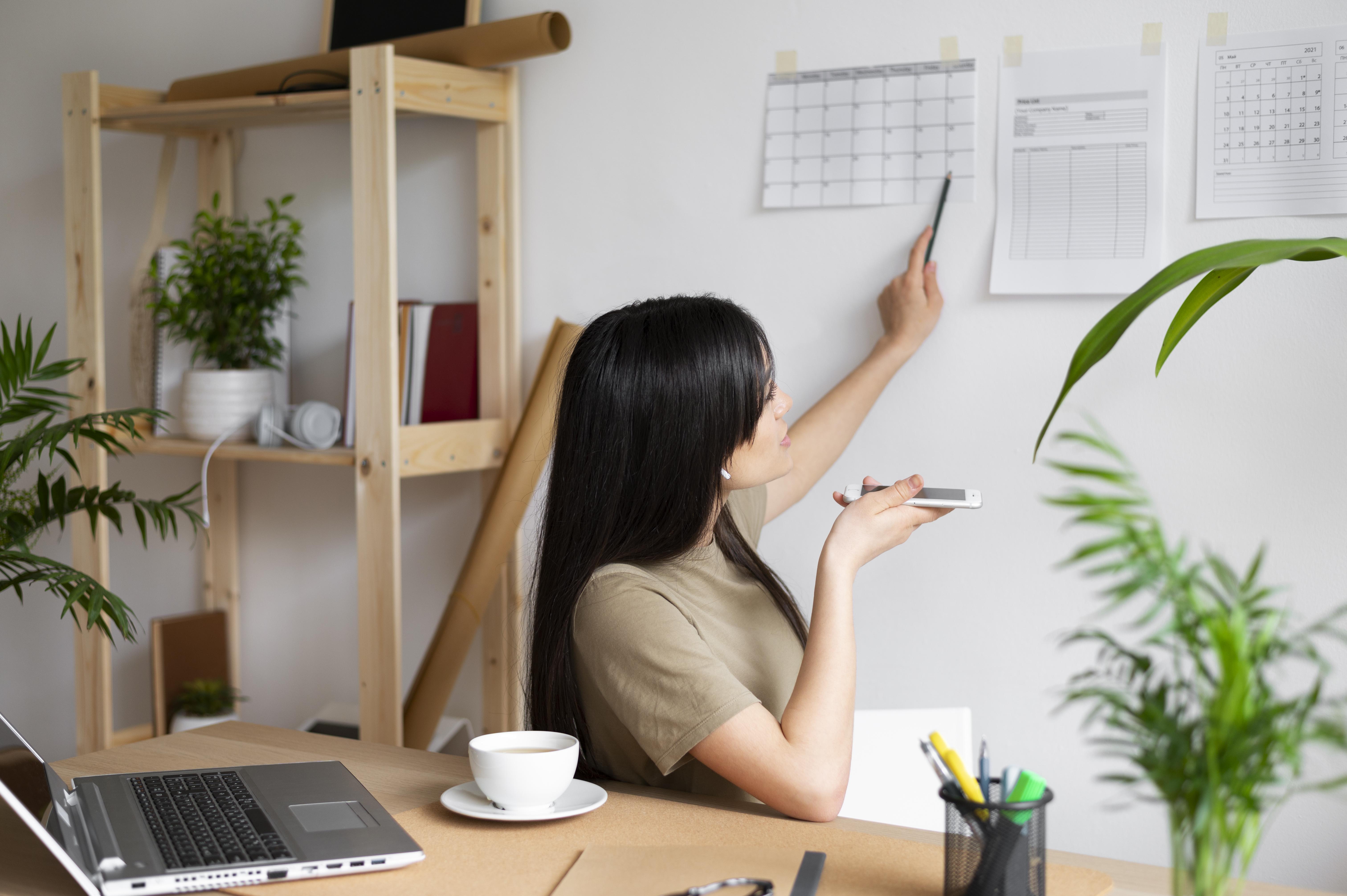 Self-employed woman managing her schedule while working from home Self-employed woman managing her schedule while working from home